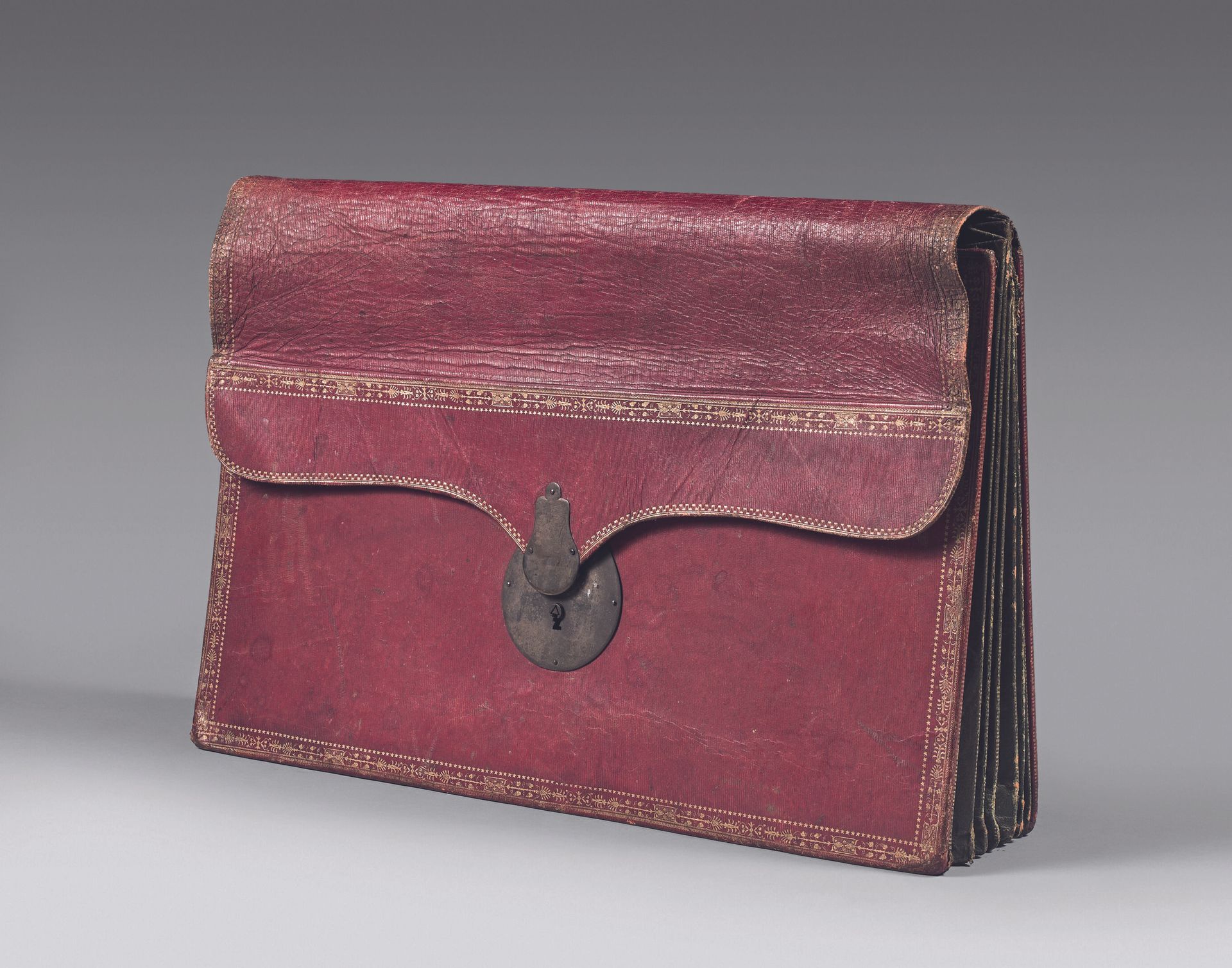 Null 镀金的摩洛哥钱包，有掌纹，里面的夹层有皮革和蓝色塔比斯。钢制锁，有三角形的锁筒。 
19世纪初。 
37 x 49 厘米