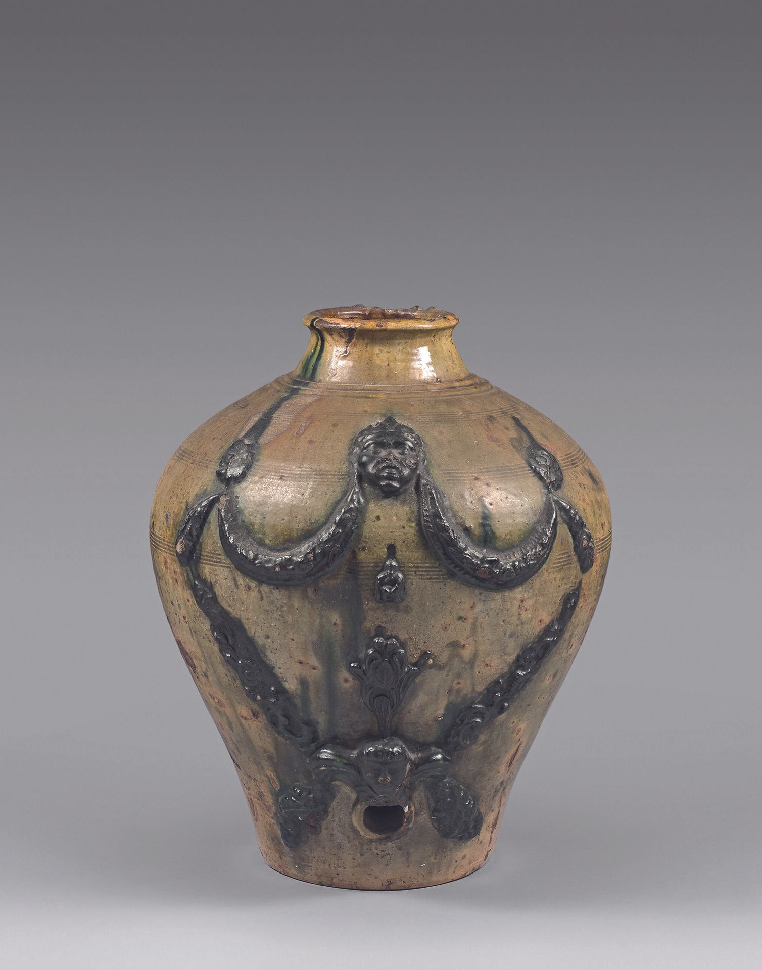 Null MIDI
釉上红陶油壶，黄绿色背景上有面具和花环的浮雕装饰。
18世纪末-19世纪初。
高度：45厘米