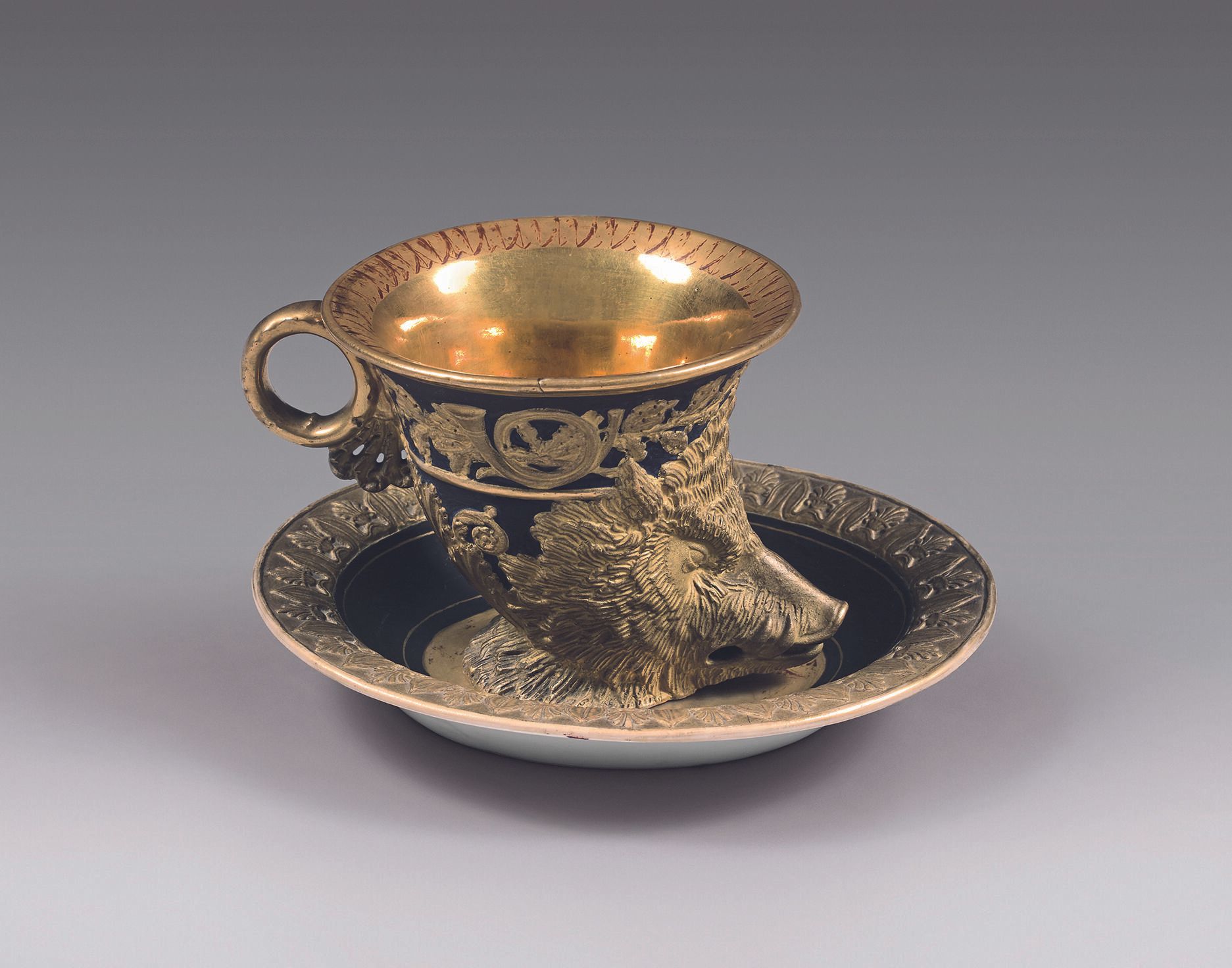 Null 巴黎
一个Rhyton杯和一个碟子，上面有蓝底浅浮雕的野猪头的鎏金装饰。
19世纪。
高度：8.5厘米