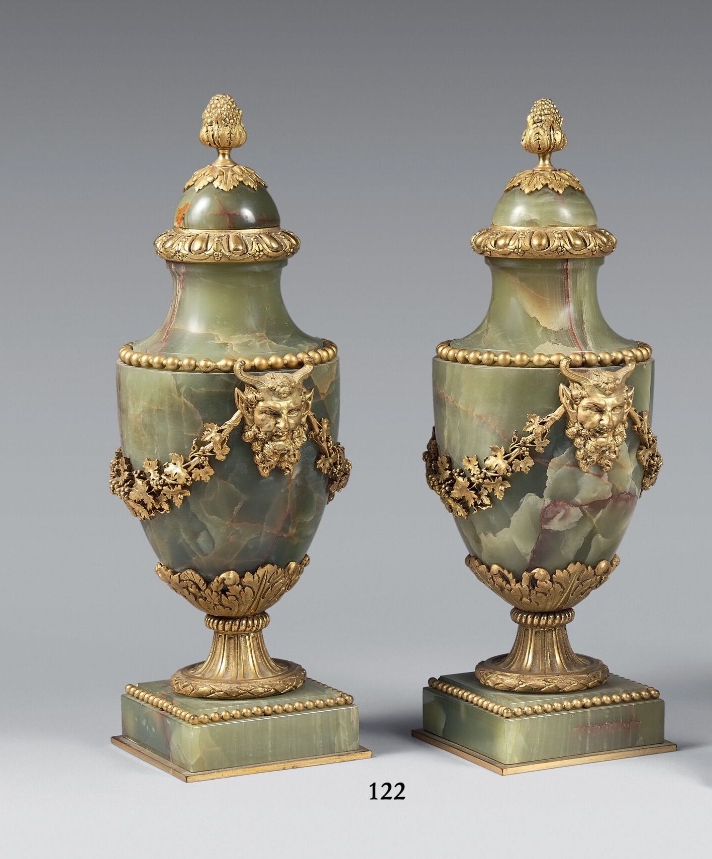 Null 一对绿色缟玛瑙覆盖的柱形花瓶，上面装饰有动物面具和藤蔓花环。 
路易十六风格。
(一个盖子略微丢失)。 
高度：34厘米