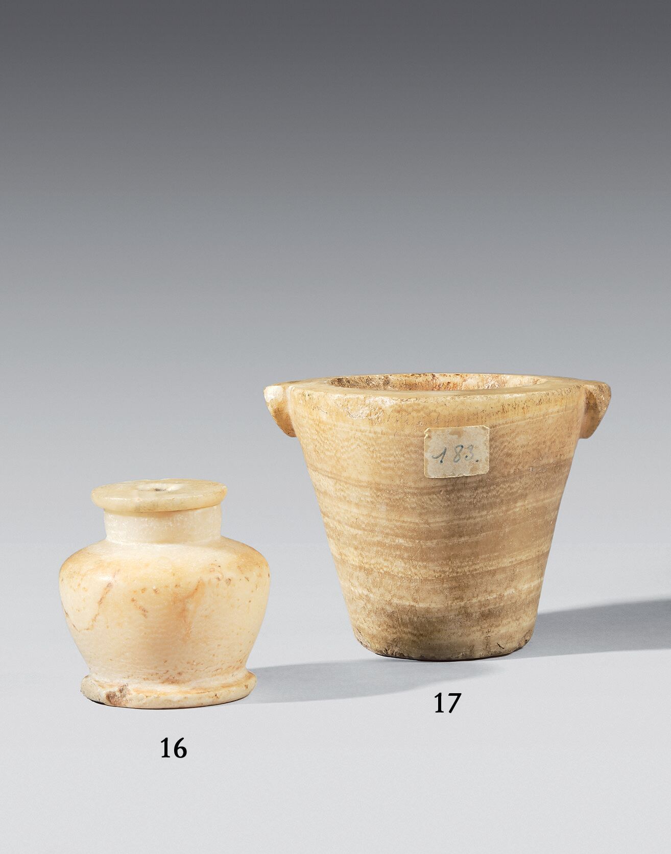 Null 截顶的圆锥形花瓶，有两个小把手，带状雪花石。
小碎片。
埃及，晚期。
高度：10厘米