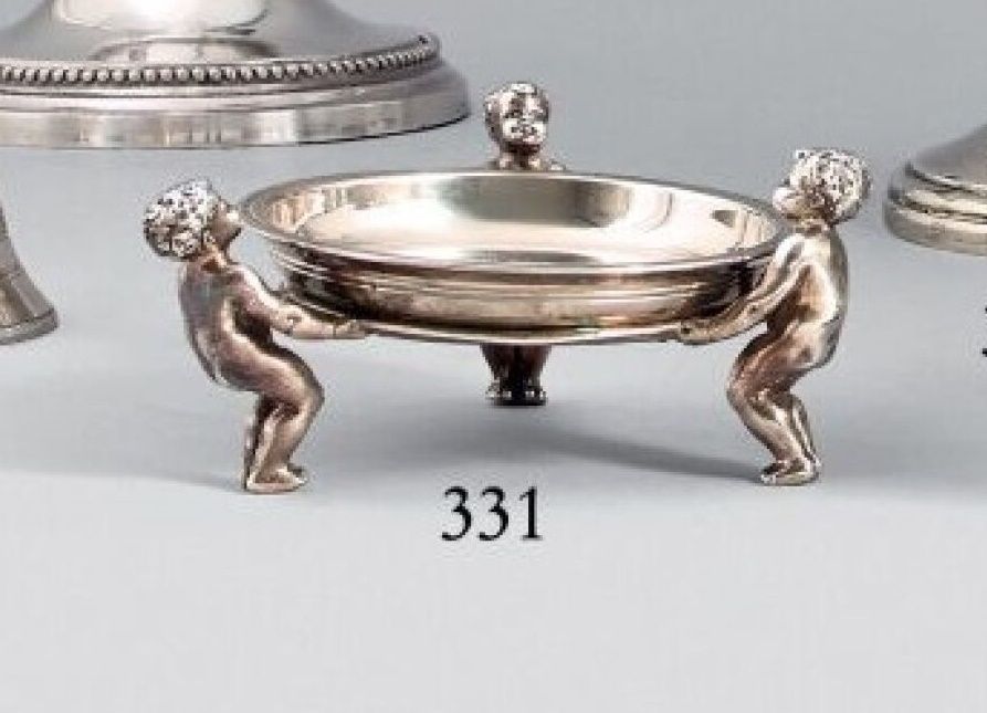 Null Round dish on a tripod display formed of putti in 925 thousandths silver. 
&hellip;