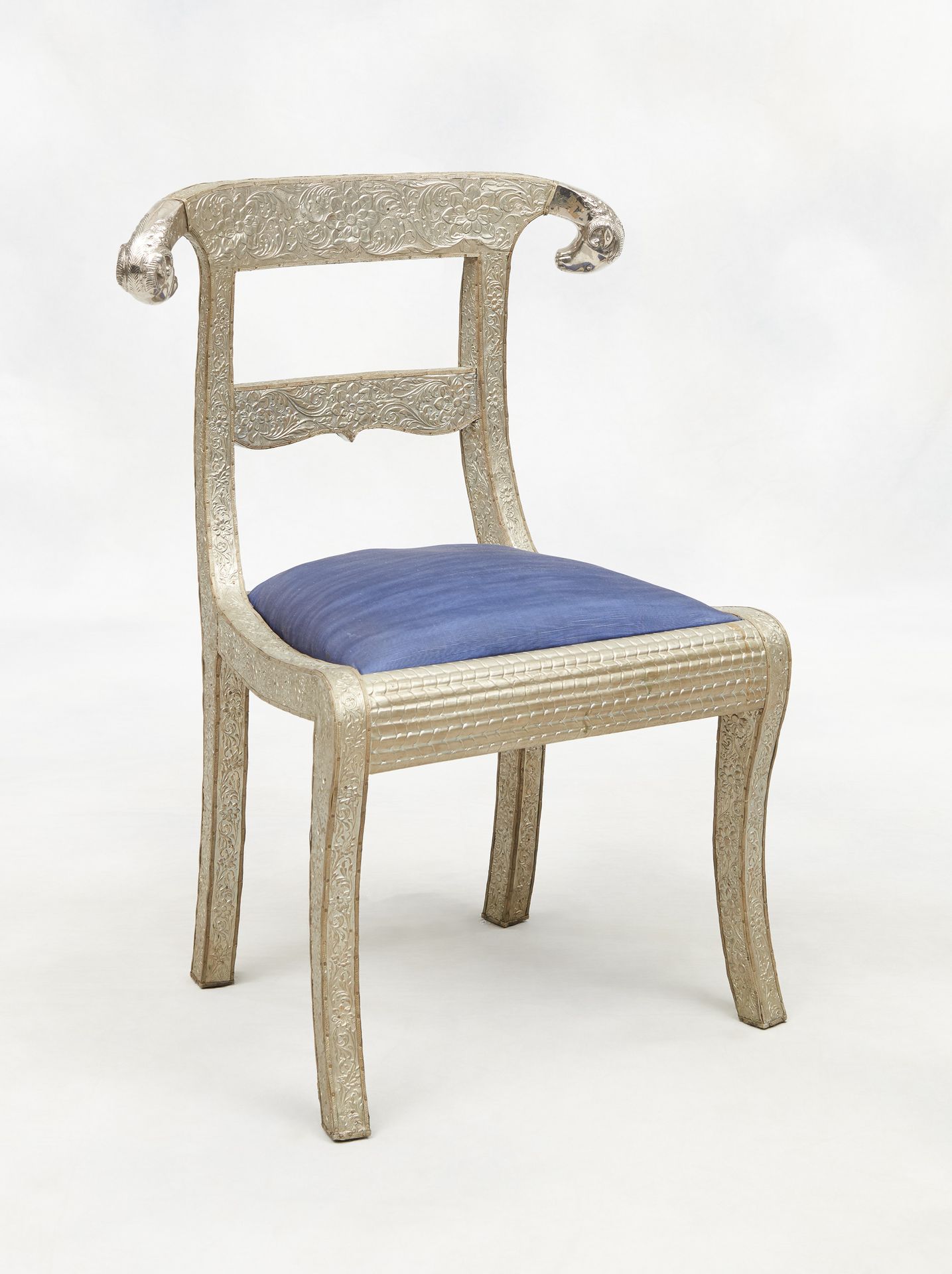 Travail anglo-indien milieu 20e. 家具：一套六把芒果木椅子，上面覆盖着压花银铜，上部有两个公羊头，靠在剑腿上。