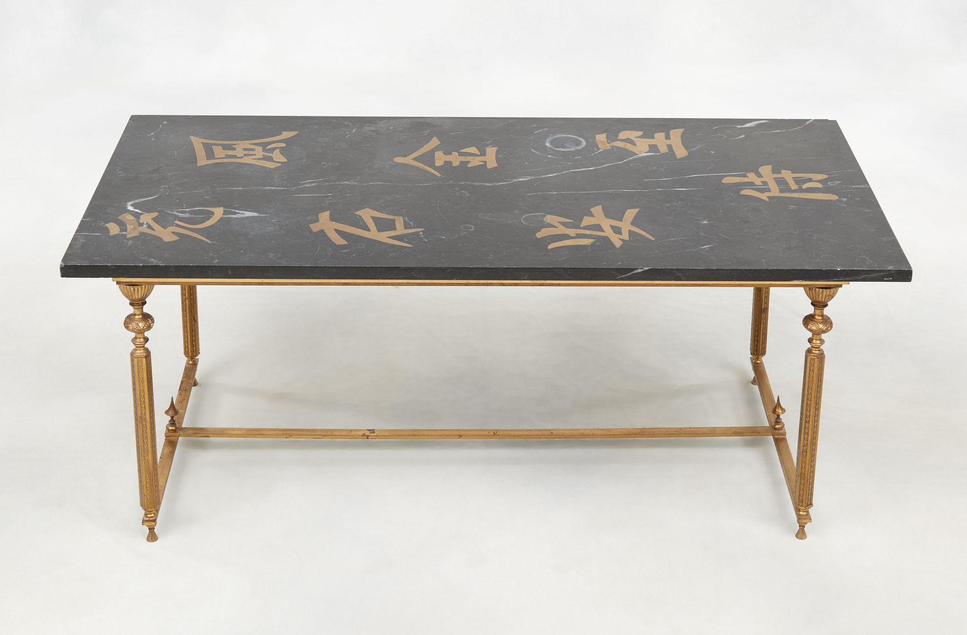 Circa 1960. 家具：铜质底座的咖啡桌，黑色大理石桌面上有亚洲文字。

在查尔斯之家的味道里。

尺寸：高：45,5 宽：115 深：54 厘米。