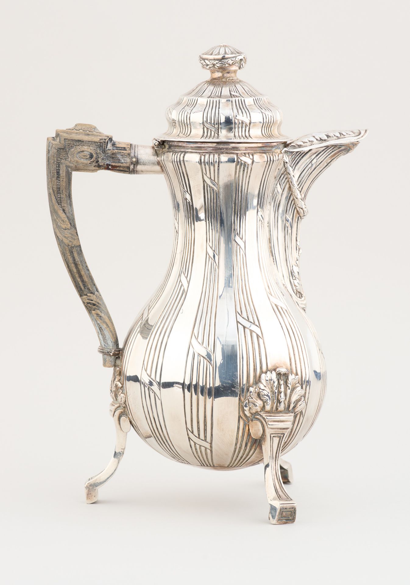 Travail belge 18e. 银器：优雅的银质咖啡壶，三足，雕花木柄。

蒙斯的标志(17)88。

尺寸：高：31厘米。

见插图。