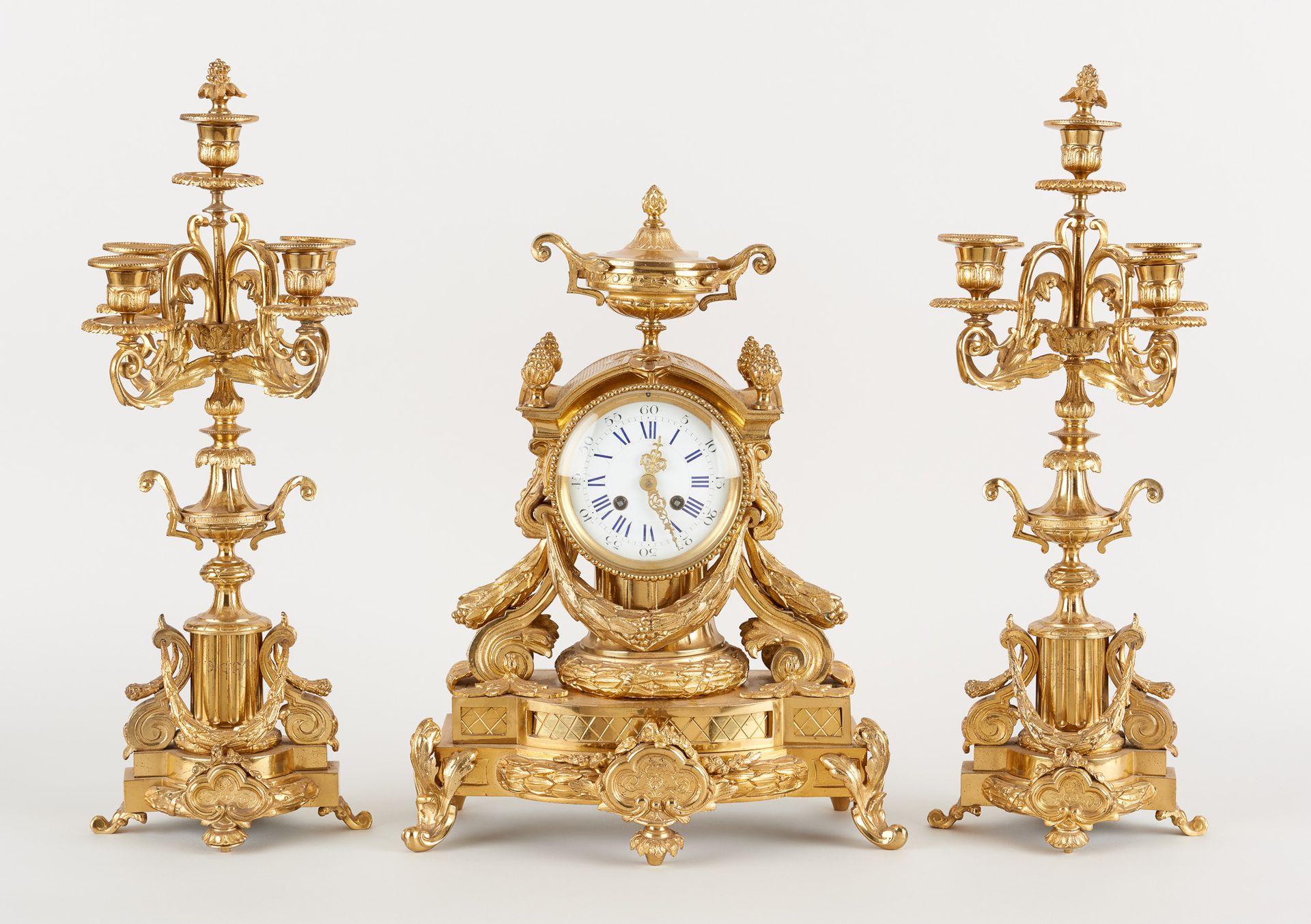 Travail belge circa 1900. 发条：鎏金青铜壁炉，由一个时钟和两个有五个灯臂的烛台组成。

尺寸：高44和52厘米。