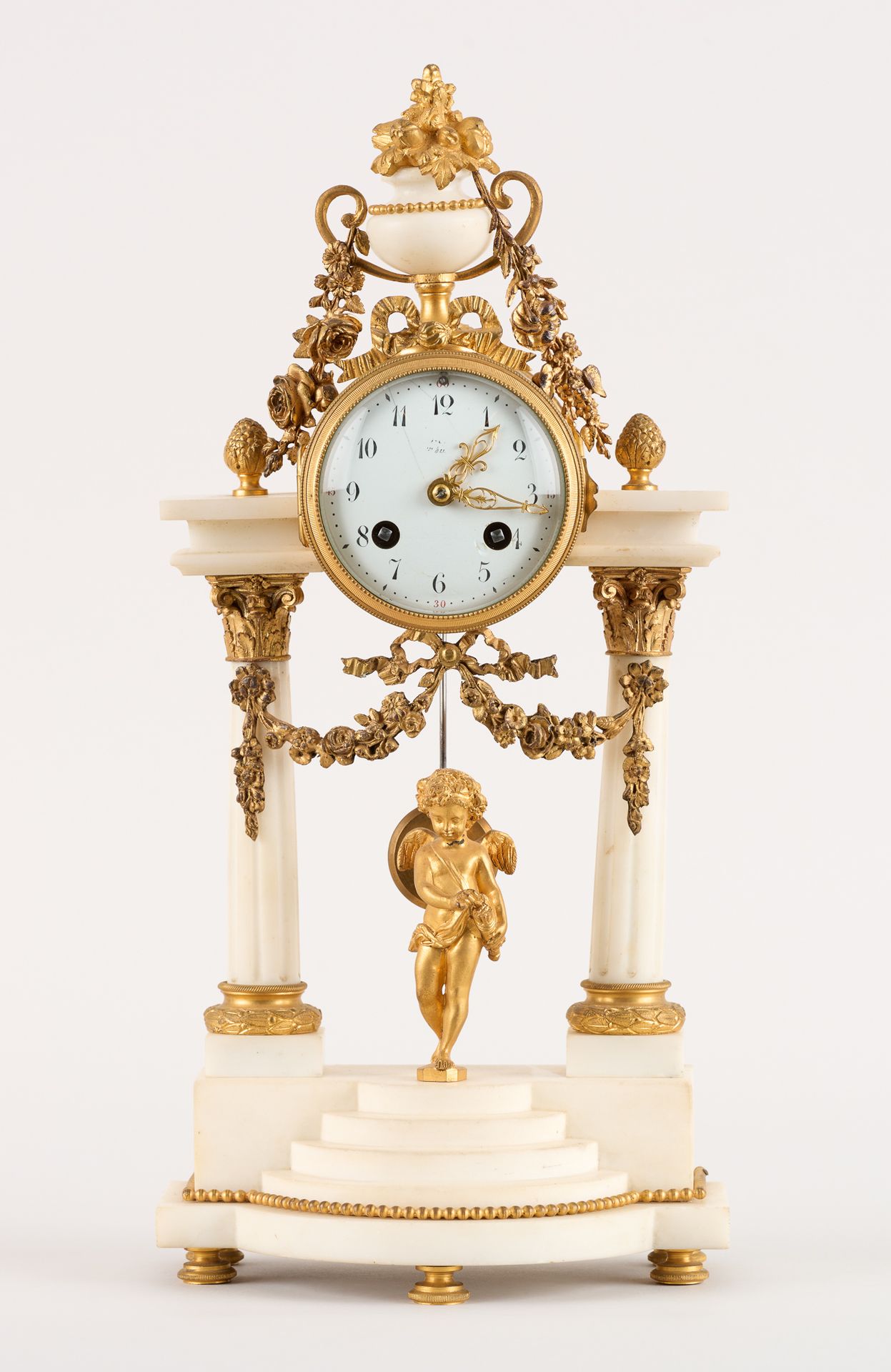 De style Louis XVI. 发条：白色大理石和鎏金青铜门廊小钟，珐琅表盘，金属悬挂机芯。

尺寸：高：45厘米。