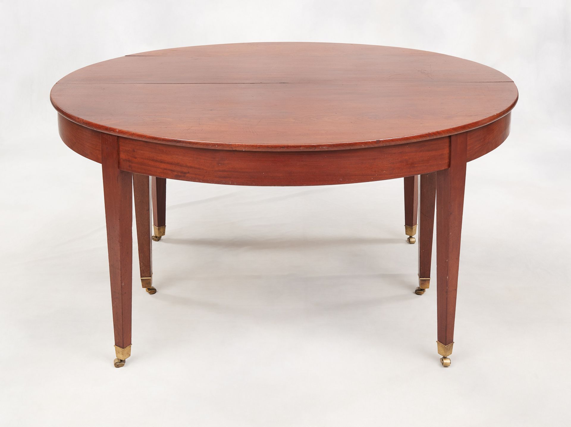 Travail du 19e. 家具：桃花心木餐桌，带有扩展系统，靠在六条纺锤形腿上，末端有脚轮。

闭合尺寸：高：73 宽：115 深：140 厘米。
