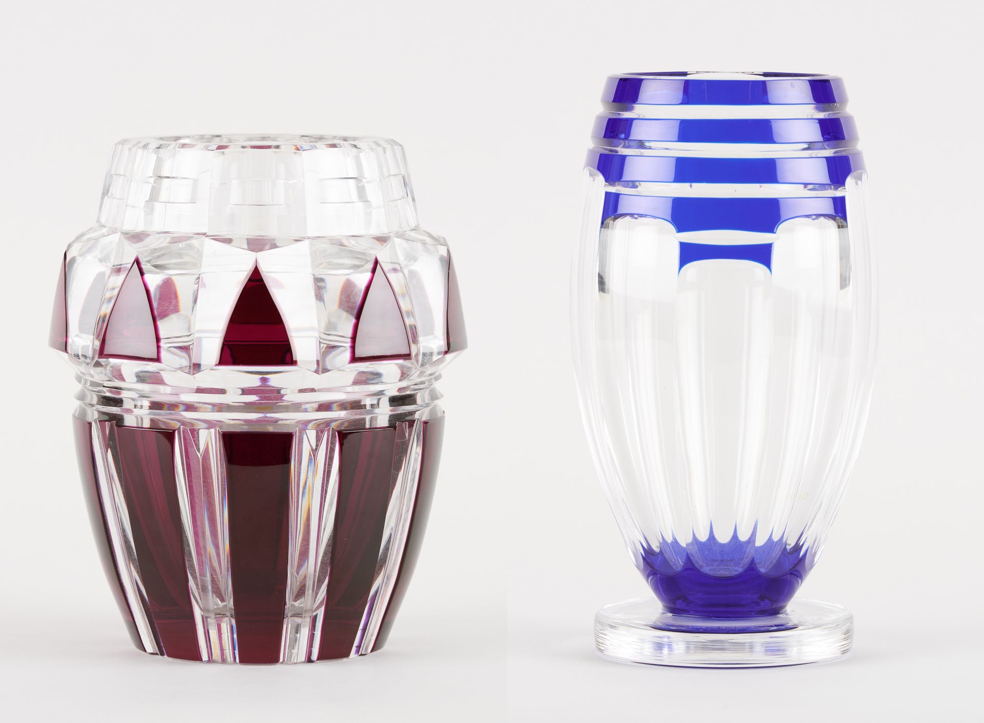 VAL SAINT LAMBERT. 玻璃器皿：由两个蓝色和酒红色衬里的透明切割水晶花瓶组成的拍品。

现附上一份文件。

尺寸：高24和20厘米。