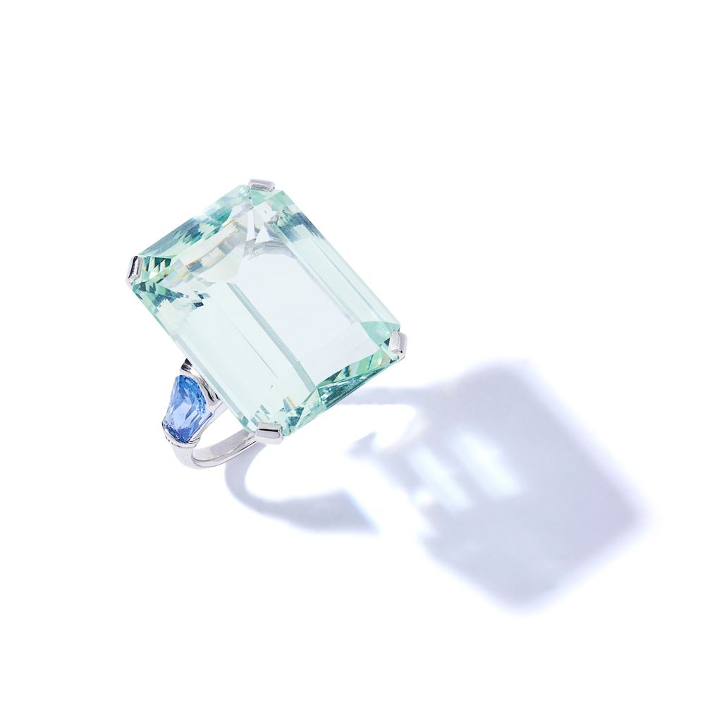 An aquamarine and sapphire dress ring 阶梯式切割的海蓝宝石，在花式切割的蓝宝石肩部之间

 （戒指尺寸：N）