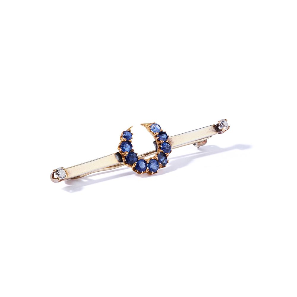 A late 19th century sapphire and diamond-set brooch 设计为椭圆形切割的蓝宝石月牙，安装在带有旧切割钻石终端的&hellip;