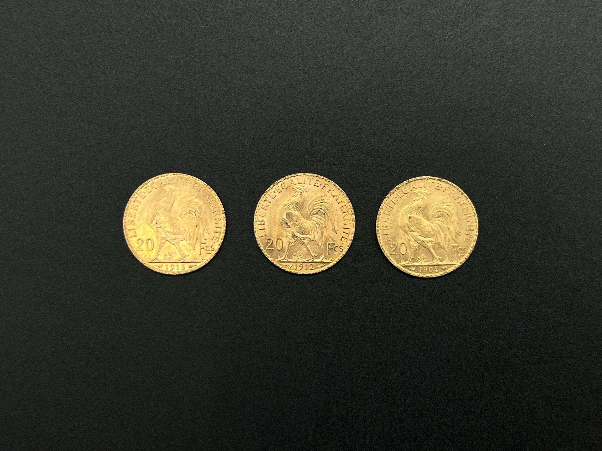 Null 一批3枚带有公鸡的20法郎金币，包括:

- 1913年

- 1912年

- 1904年

总重量：19,4克。

穿着。
