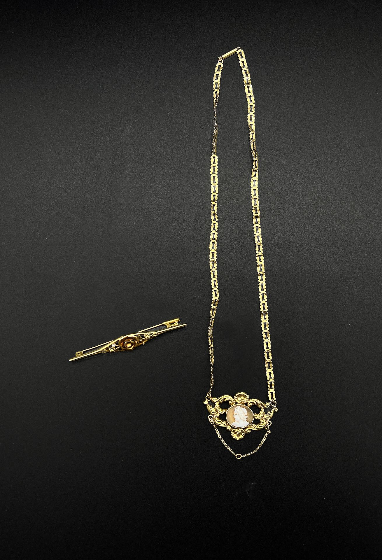 Null 一批黄金(750)首饰包括:

- 一条有叶子图案和镂空链条的项链，中心是一个描绘男性形象的浮雕。

P.毛重：6克。

- 一枚玫瑰图案的黄金胸针。&hellip;