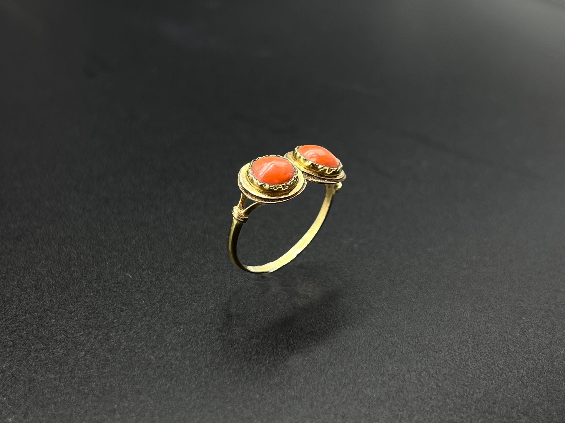 Null 黄金（750）戒指，镶嵌有两个小的圆形珊瑚凸面体。

19世纪的作品。

毛重：2.3克。