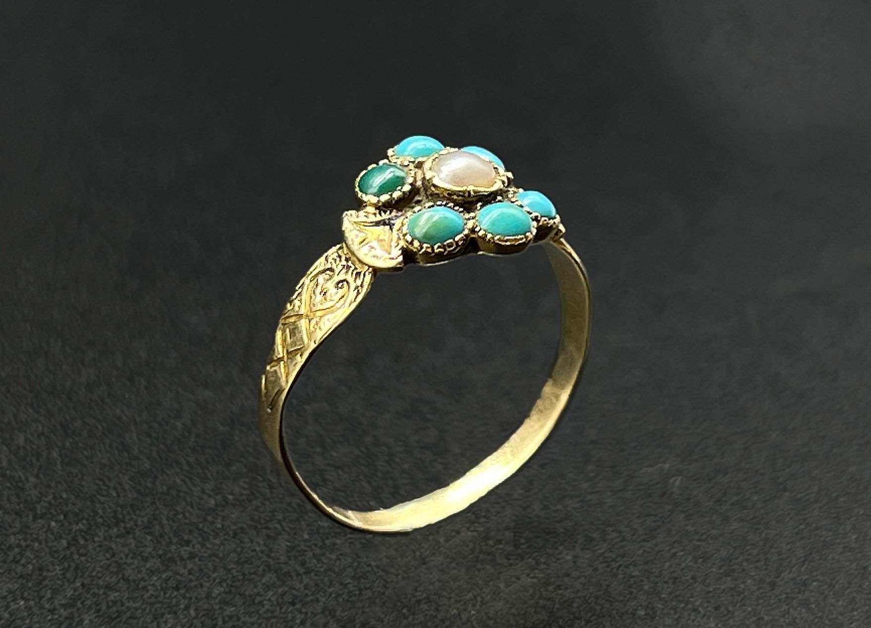 Null 黄金（750）戒指，中心是由小圆绿松石凸圆形组成的风格化花朵设计，中心是一颗珍珠。

雕刻的装饰。

毛重：1.8克。

略有意外，有一颗绿松石已经绝&hellip;