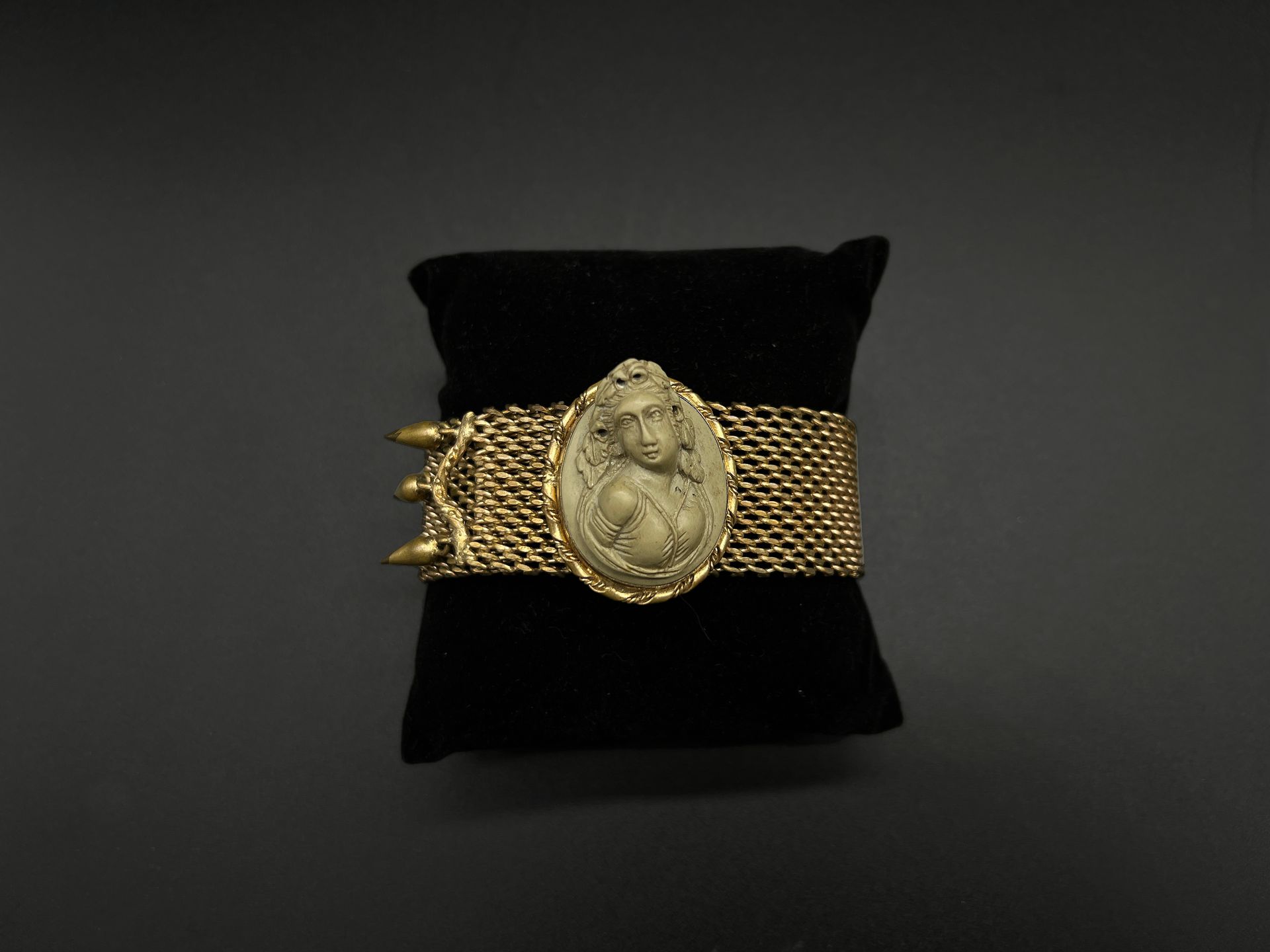 Null 意大利，19世纪末-20世纪初

鎏金金属手镯丝带上装饰有熔岩石奖章，显示了一个女性半身浮雕。

氧化作用。