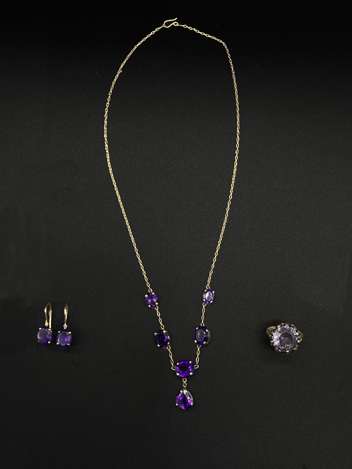 Null 一半以14K（585千分之一）黄金镶嵌，包括一条饰有刻面椭圆紫水晶和一个梨形紫水晶吊坠的垂坠项链和一对饰有紫水晶的耳环（Dormeuses）。用于打耳&hellip;