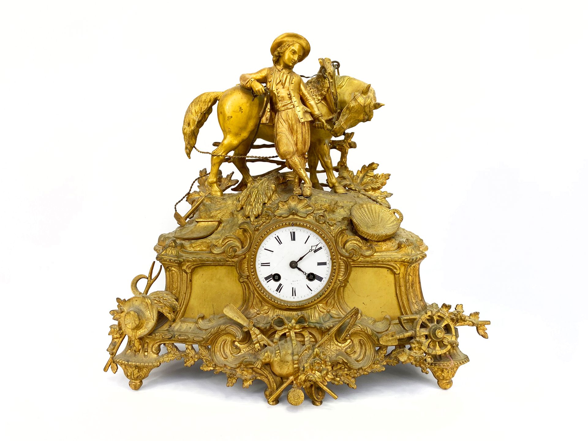 Null 鎏金铜和红铜钟，上面有一个骑马的小男孩。

安放在一个装饰有狩猎战利品和花篮的底座上。

搪瓷表盘上的罗马数字代表小时，铁路代表分钟。

H.38厘米&hellip;