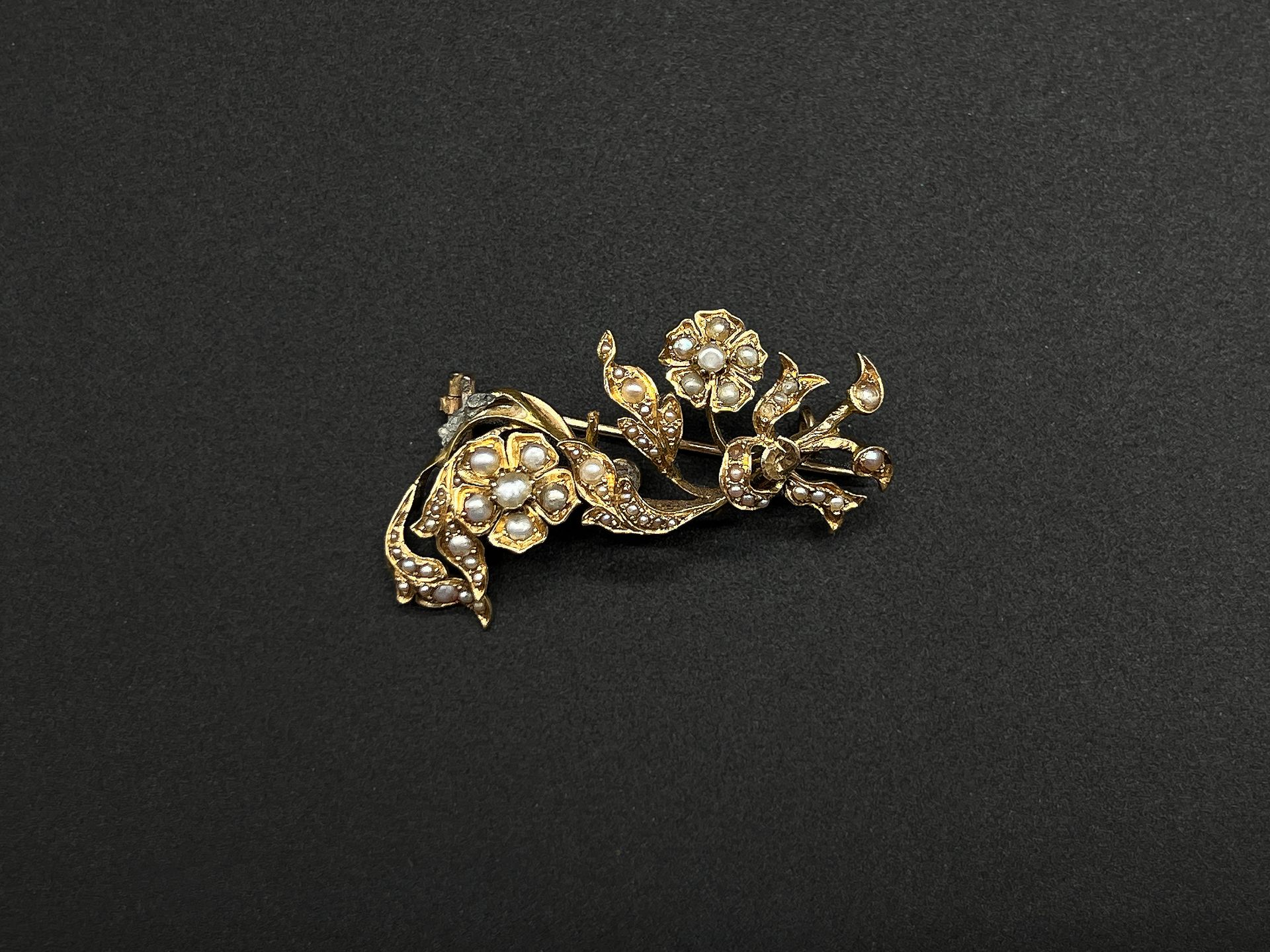 Null 黄金（750）胸针，以花束和带状蝴蝶结为特色，上面装饰着小养殖珍珠。

重量：6.1克。