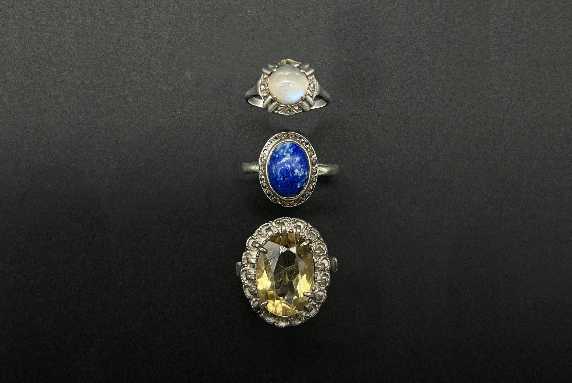 Null 一套三枚银戒指（950），一枚有凸面青金石，另一枚有刻面黄石，最后一枚有凸面月光石。

19世纪末至20世纪初的作品。

P.毛重：13.7克。