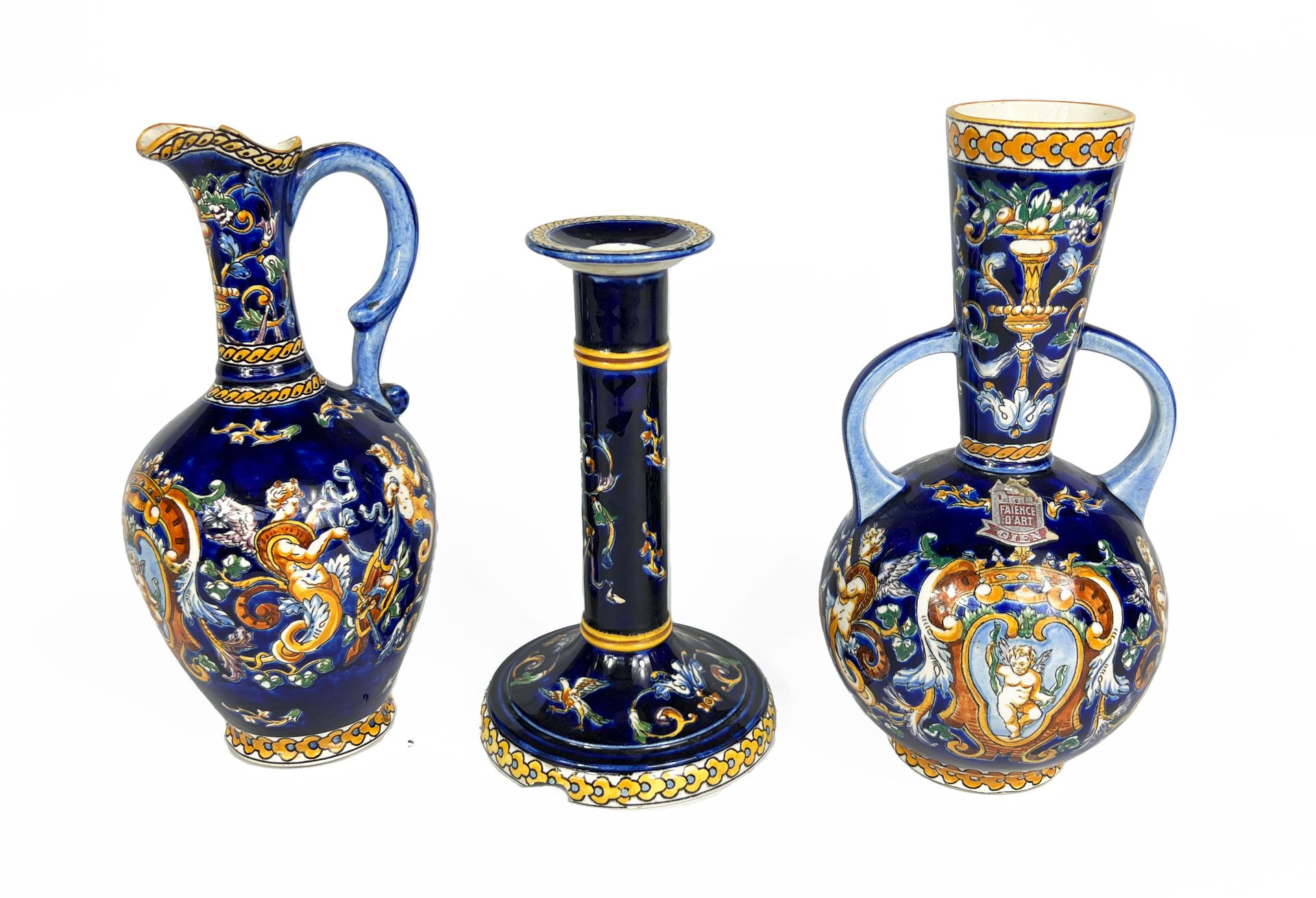 Null 吉恩，20世纪

一批带有文艺复兴时期装饰的陶器，包括:

- 一个烛台

- 一个水壶

- 颈部外翻的花瓶。

H.26厘米至22厘米