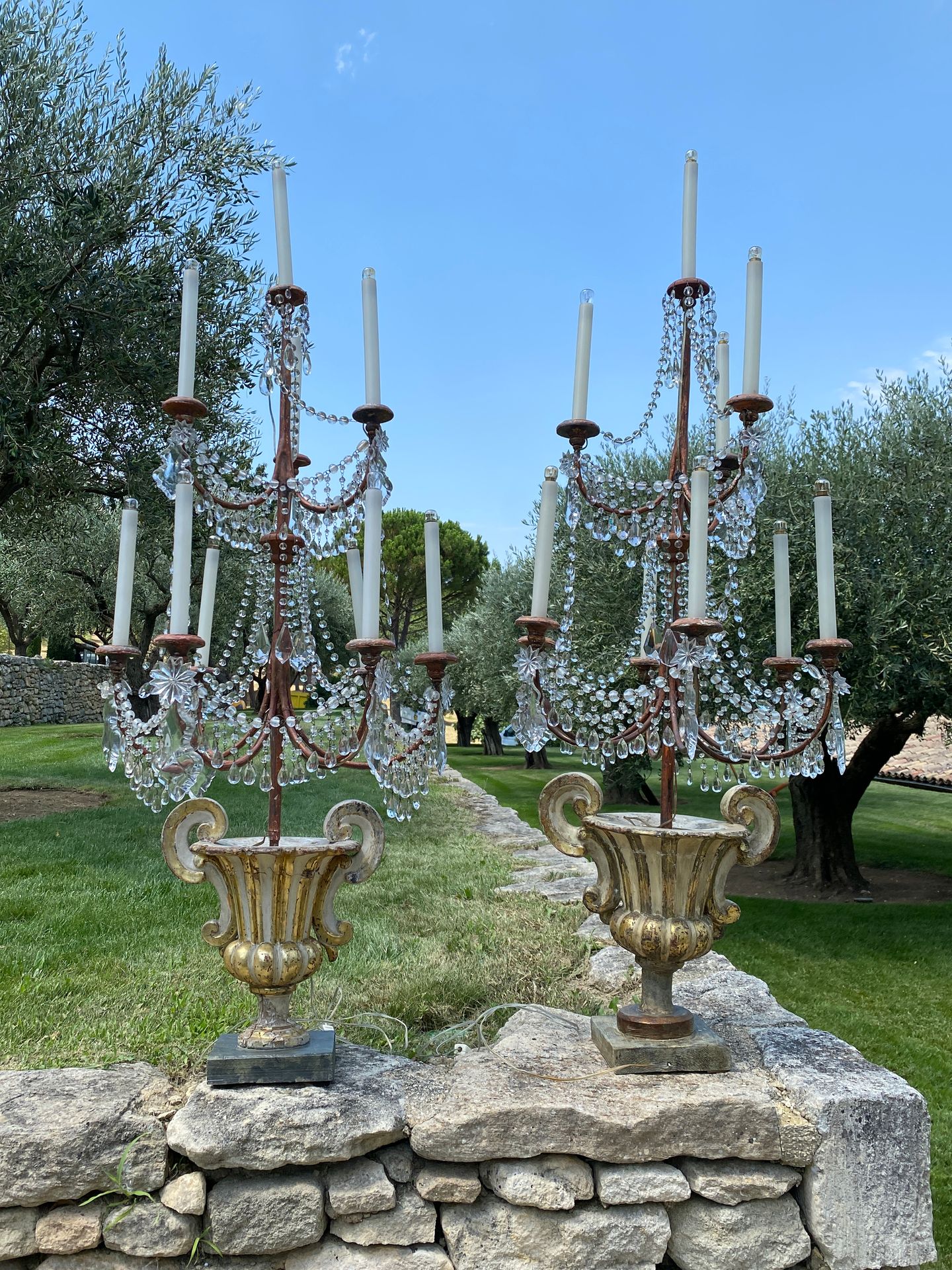 Null 一对重要的锻铁烛台，有六个灯臂和水晶吊坠。

底座由一个带两个手柄的花瓶组成，奶油色和金色的漆面雕刻木头，上面有锯齿状的图案。

H.160厘米