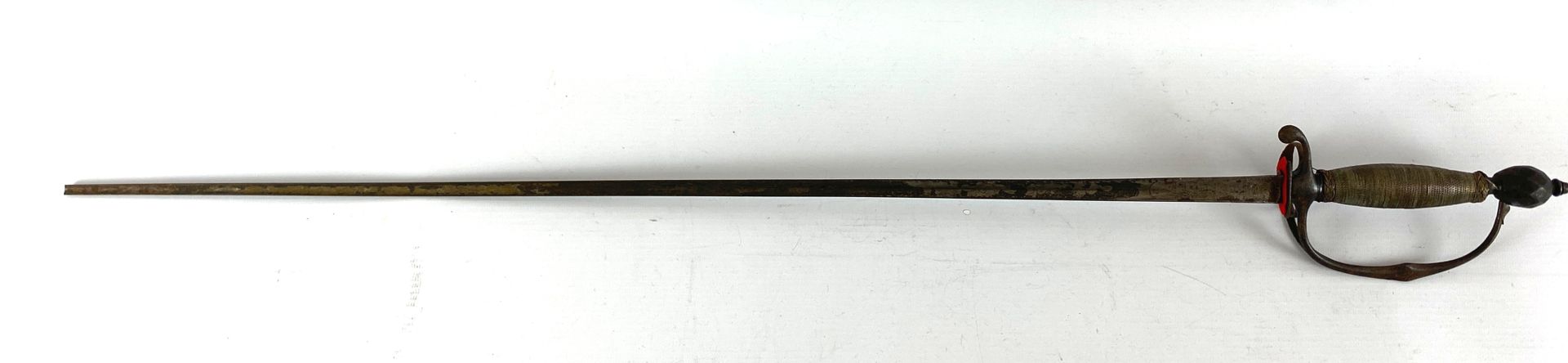Null 18世纪的床头小剑。铁和银的安装。琢磨过的橄榄形鞍座，护卫枝分成两个，形成弯曲的水滴状奎隆和一个护卫环。木质导火线上覆盖着银色的丝线（可能是添加的）和&hellip;