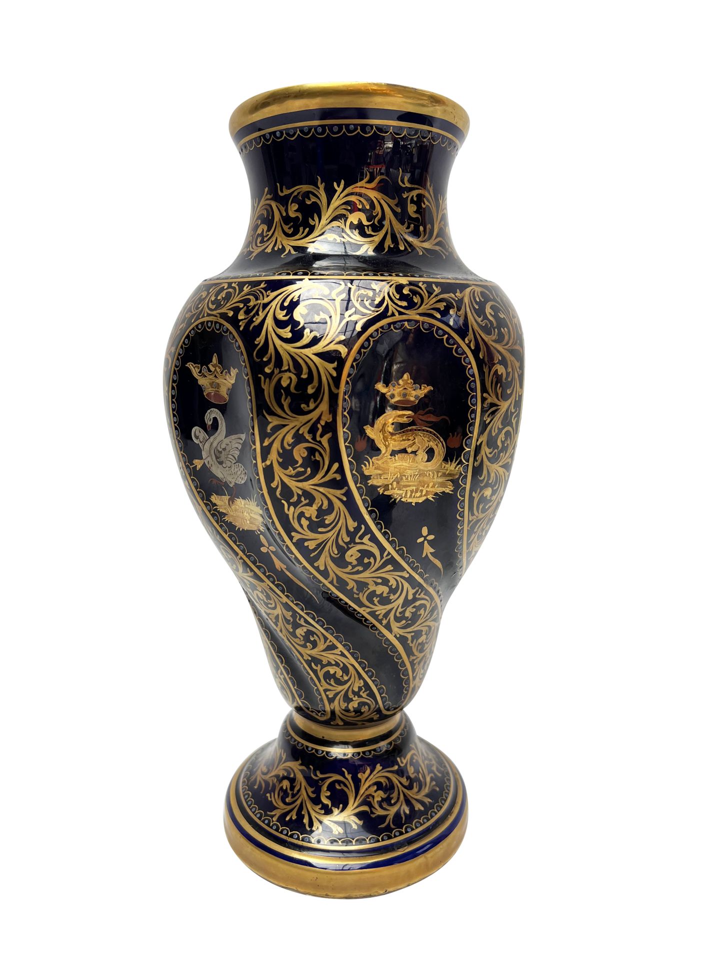 Null 19世纪末的作品、
深夜蓝色背景的陶瓷基座上的柱状花瓶，瓶身有一个躯干图案。
丰富的多色装饰，蝾螈、朱雀和天鹅的冠冕与纹章图案交替出现。
叶子的镀金亮&hellip;