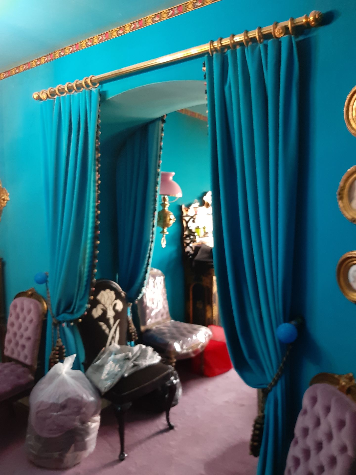 Null 
绿松石蓝色天鹅绒的窗帘和帝国风格的镀金和铜化金属的窗帘杆。现代。