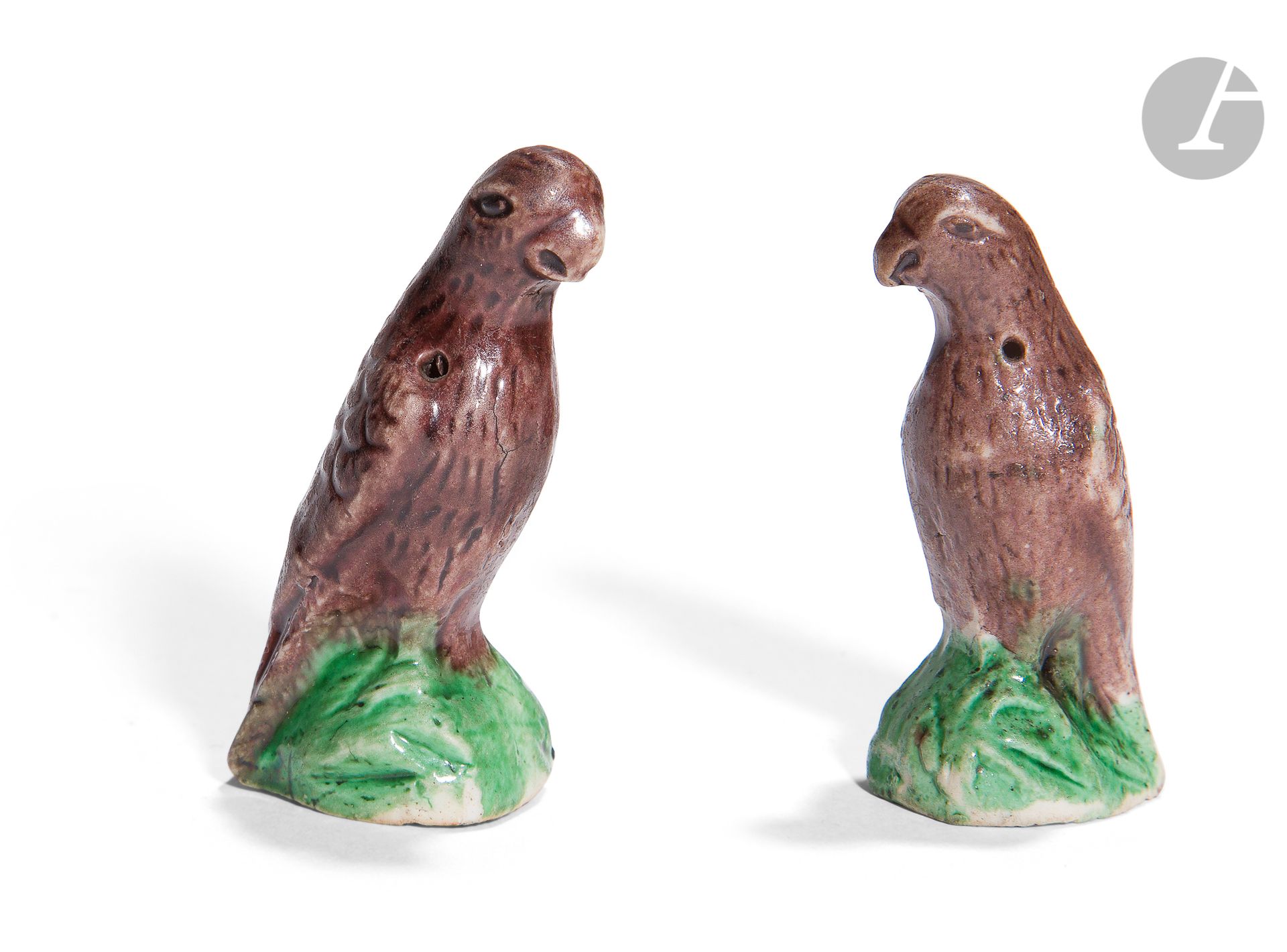 Null 一对珐琅彩小鹦鹉，中国，康熙时期（1662-1722）。 珐琅彩锰质小
鹦鹉，靠在绿色珐琅彩岩石上
。
未上釉的饼干底部用黑色墨水标明了一个古老的存货&hellip;