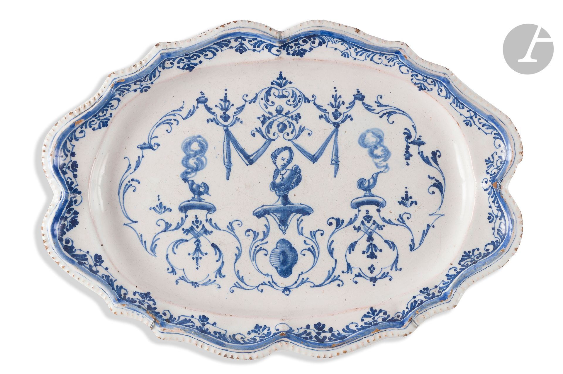 Null 
图卢兹椭圆形陶盘，边缘有轮廓，中间是蓝色的单色装饰，上面有一个女人的半身像，在窗帘和叶子的框架里有吸烟杯
。

18世纪。
长：35厘米裂缝
。