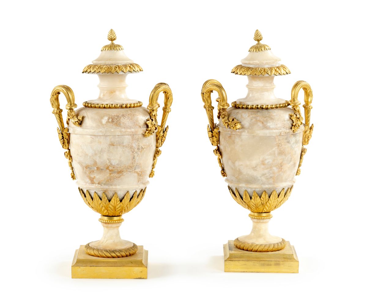 Null 
一对雪花石膏和青铜包覆的花瓶，呈柱状，镀金的青铜支架上装饰有珍珠、叶子和藤枝；（事故和修复，特别是对一个基座）。



18世纪末-19世纪初。

&hellip;