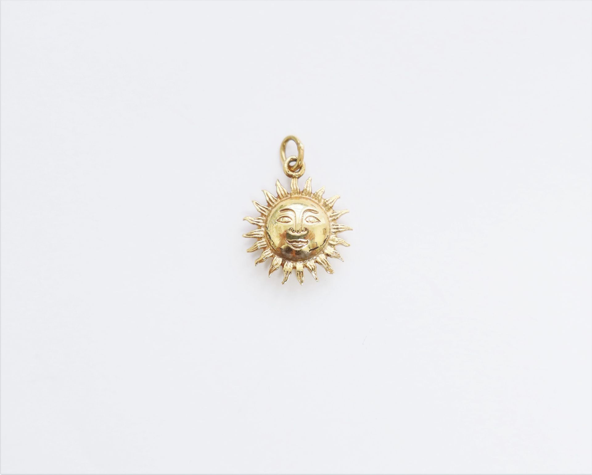 Null Pendant in 18K (750) gold representing a sun. Weight : 2 g