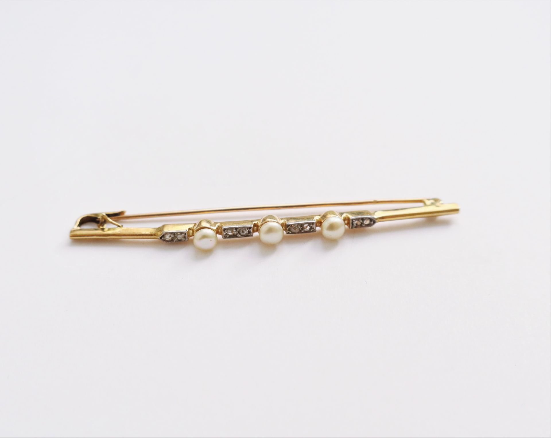 Null 18K（750）金胸针，镶嵌3颗纽扣珍珠和玫瑰切割钻石。20世纪初的作品。长度：6.5厘米左右。毛重：4克