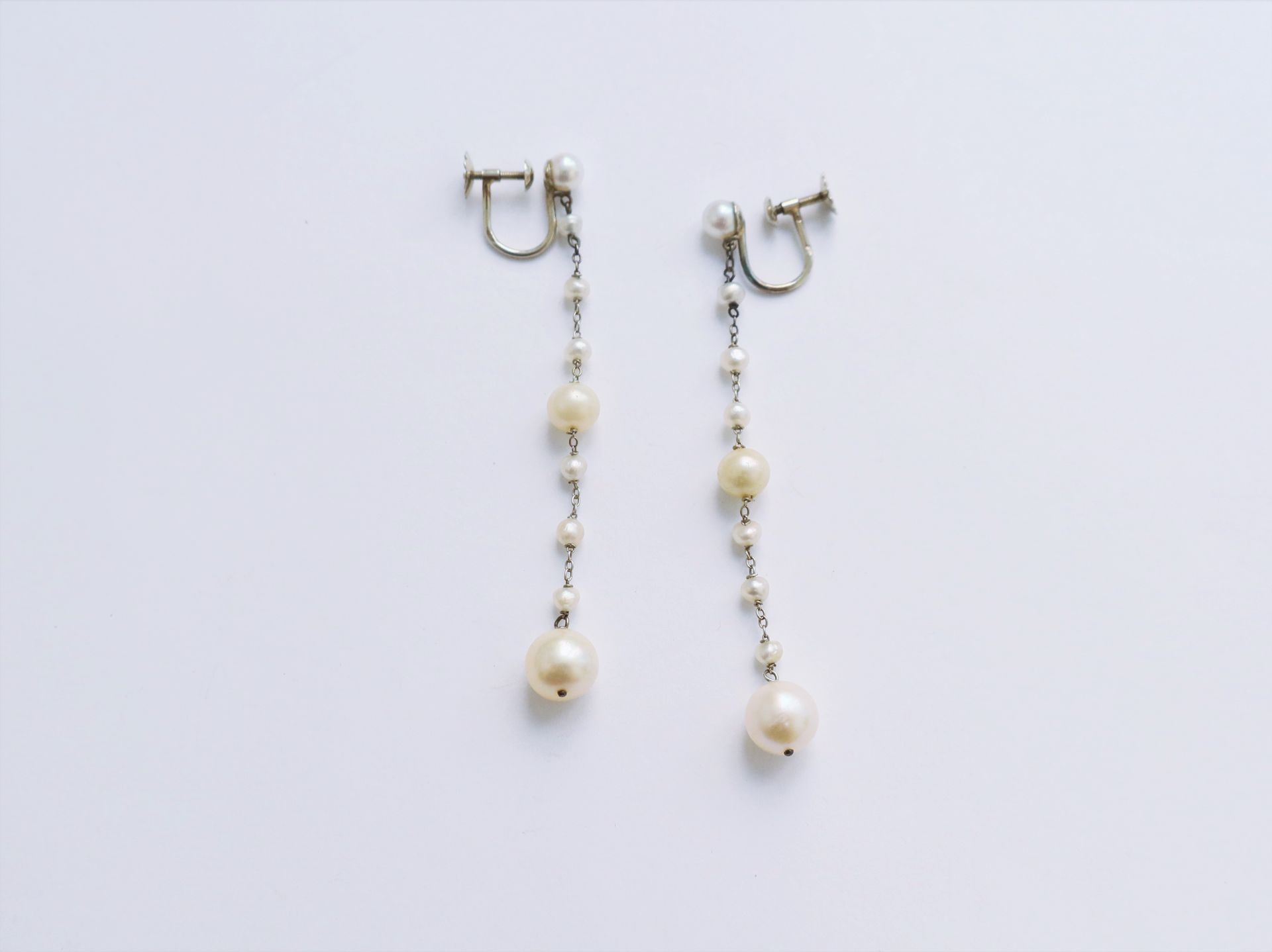 Null 一对18K(750)白金耳环，每一对都装饰有圆形或巴洛克式的养殖珍珠。法国的工作。高度：约6.4厘米。毛重：4.3克（2颗假珍珠