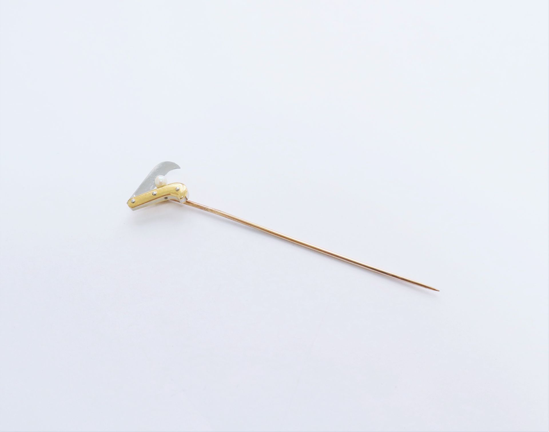 Null 18K（750）金襟针，有一把握着珍珠的笔刀。毛重 : 4,1 g