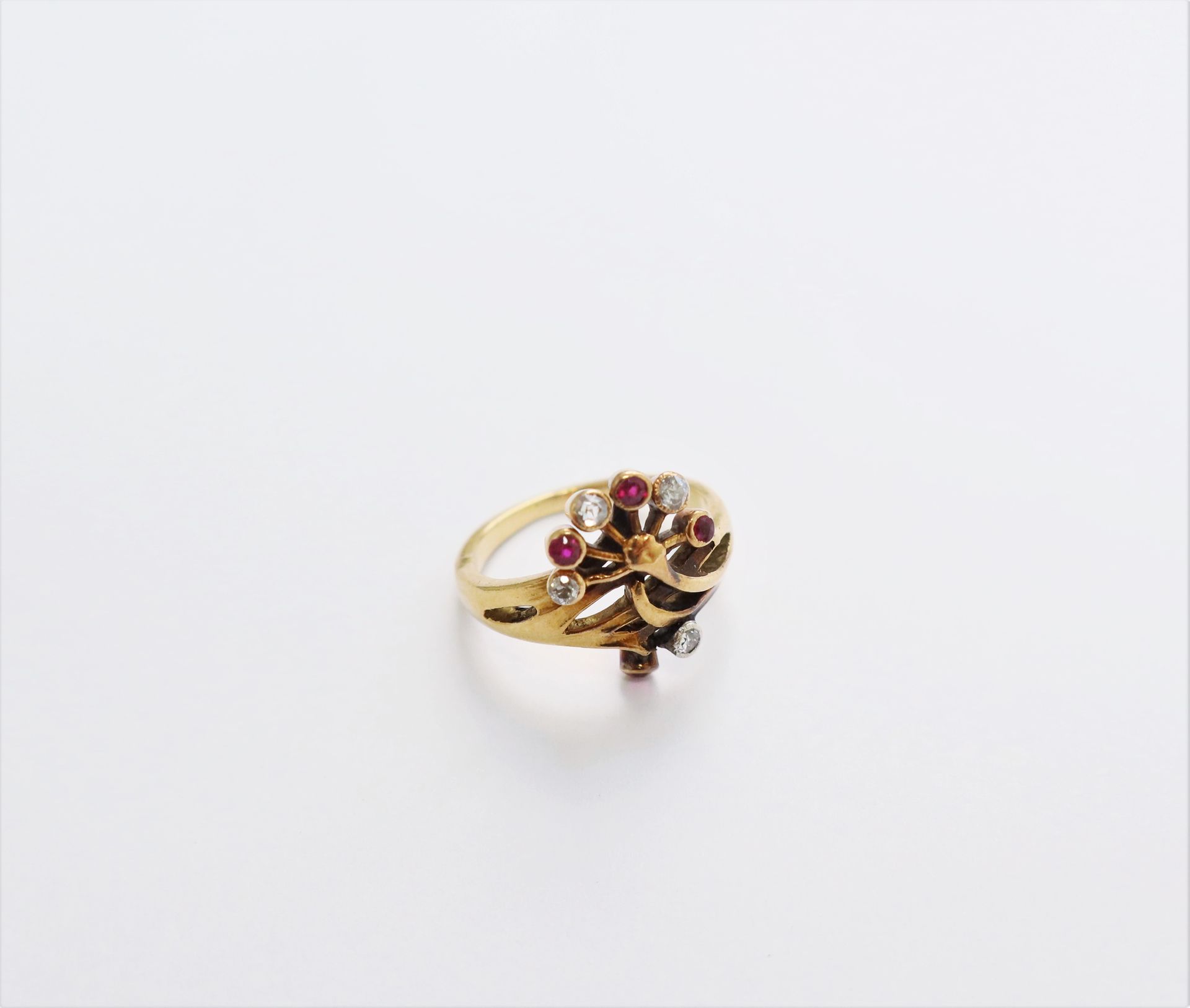 Null 一枚18K(750)金戒指，带有风格化的花朵设计，镶嵌着圆形老式切割钻石和红宝石。20世纪初的作品。手指大小：53。毛重：5.3克（芯片