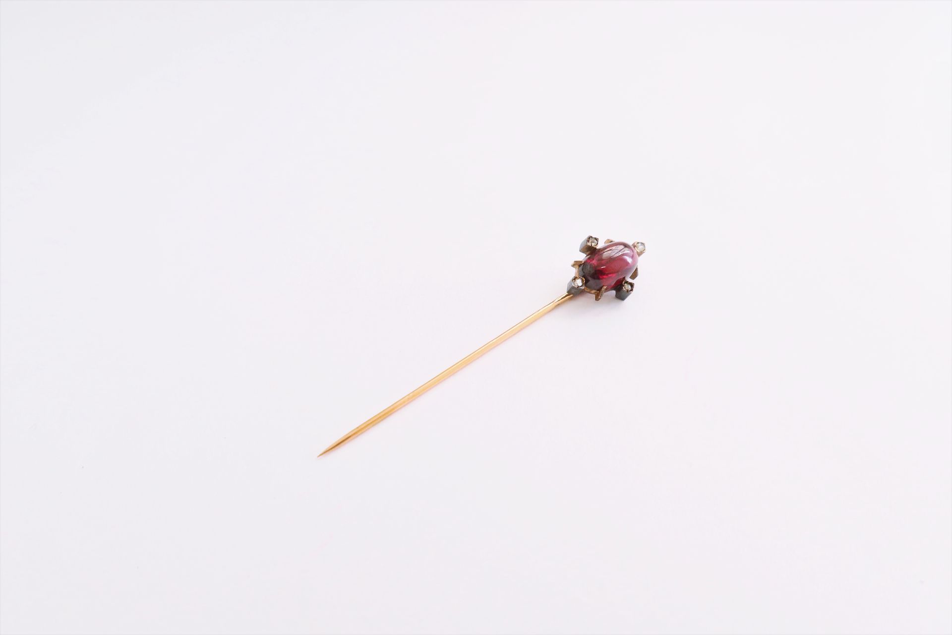Null 18K (750) gold lapel pin set with a cabochon garnet and rose-cut diamonds. &hellip;