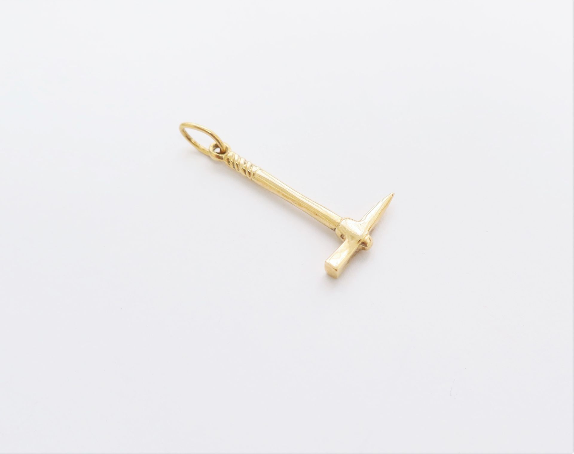 Null Companion pendant in 18K gold representing a pick. Weight : 3 g