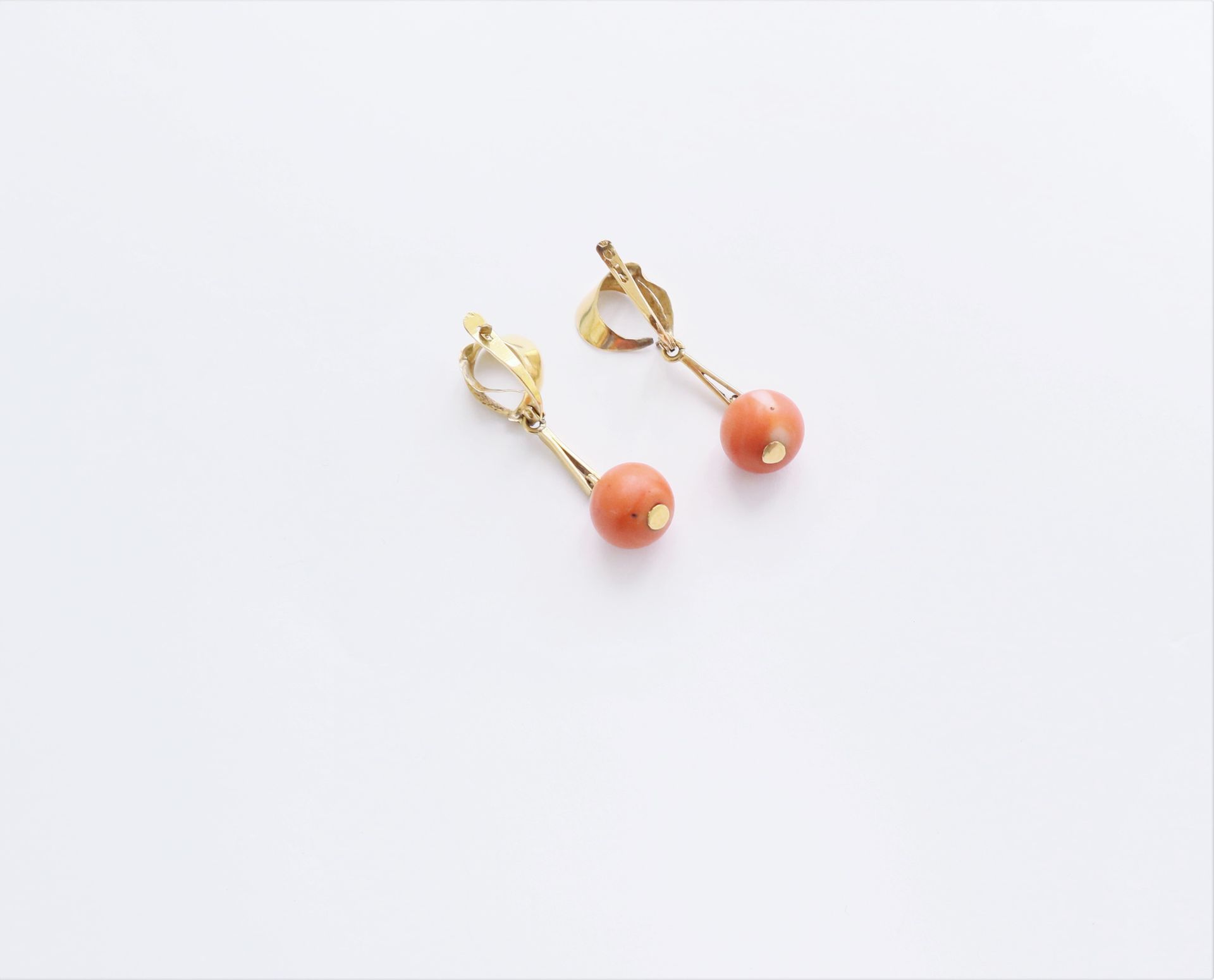 Null Pair of 18K (750) gold earrings, each with a coral bead. Weight : 5,6 g