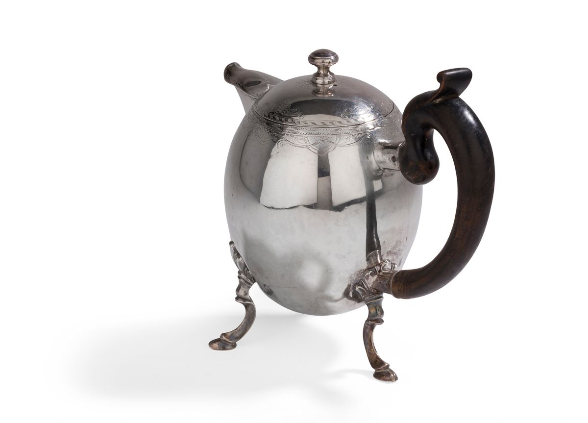 Null SWITZERLAND 18
世纪银制卵形三足
茶壶
，木质的把手有两点钩子，盖子上有一个绞盘式的把手，在盖子、壶身顶部和壶嘴的边缘刻有叶子的装饰
。&hellip;