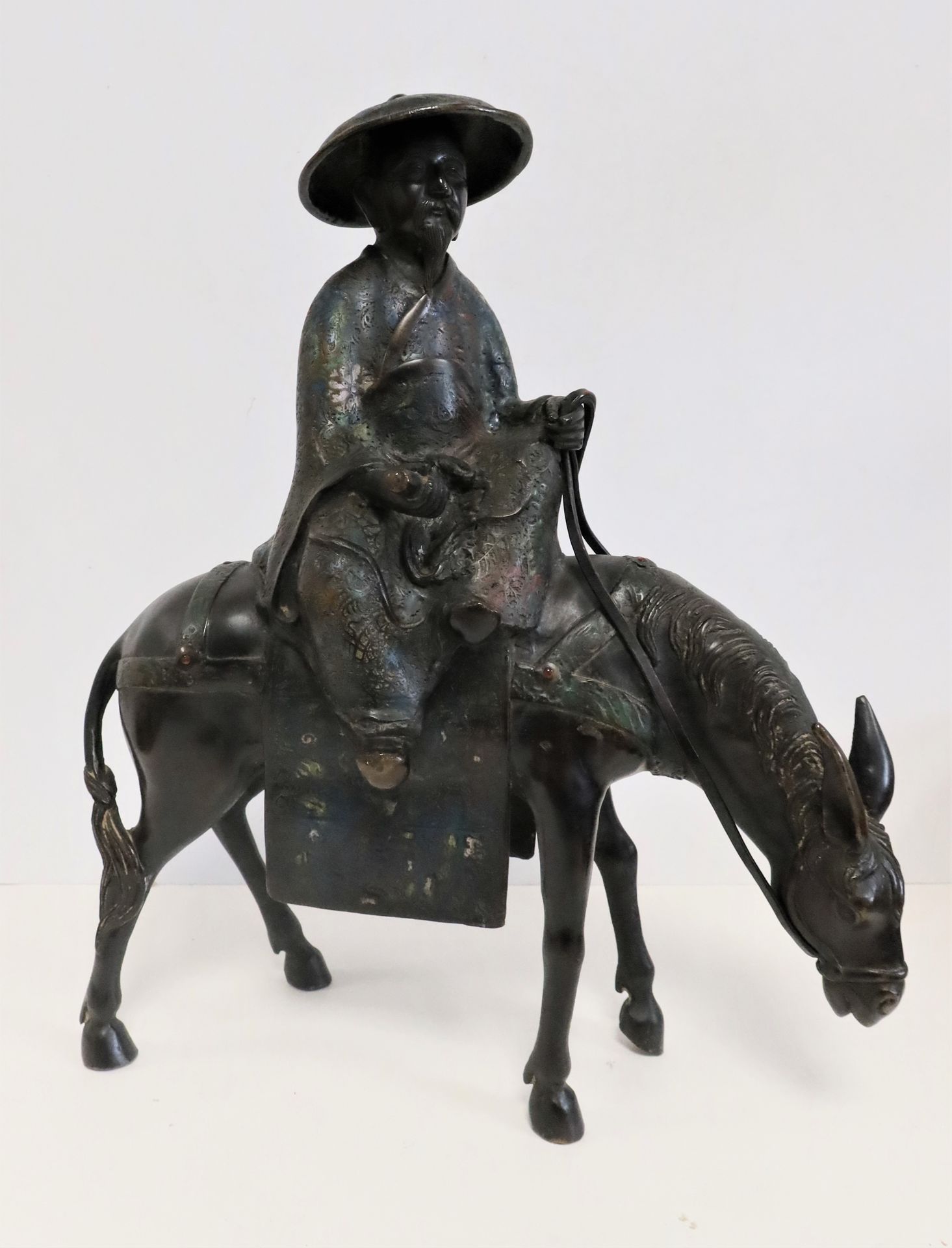 Null 骑着骡子的鸟羽，日本，约
1900年青铜雕像，绿松石蓝色背景上有棕色的铜锈和多色掐
丝珐琅。
部分褪色的珐琅彩高度
：46厘米