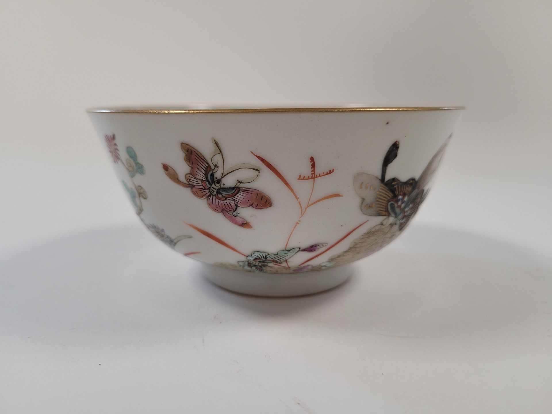 Null 瓷碗，中国，19世纪
花中有蝴蝶的多色装饰，里面有鱼
。
在底座下做标记。
高度：6.2厘米；直径：12.5厘米