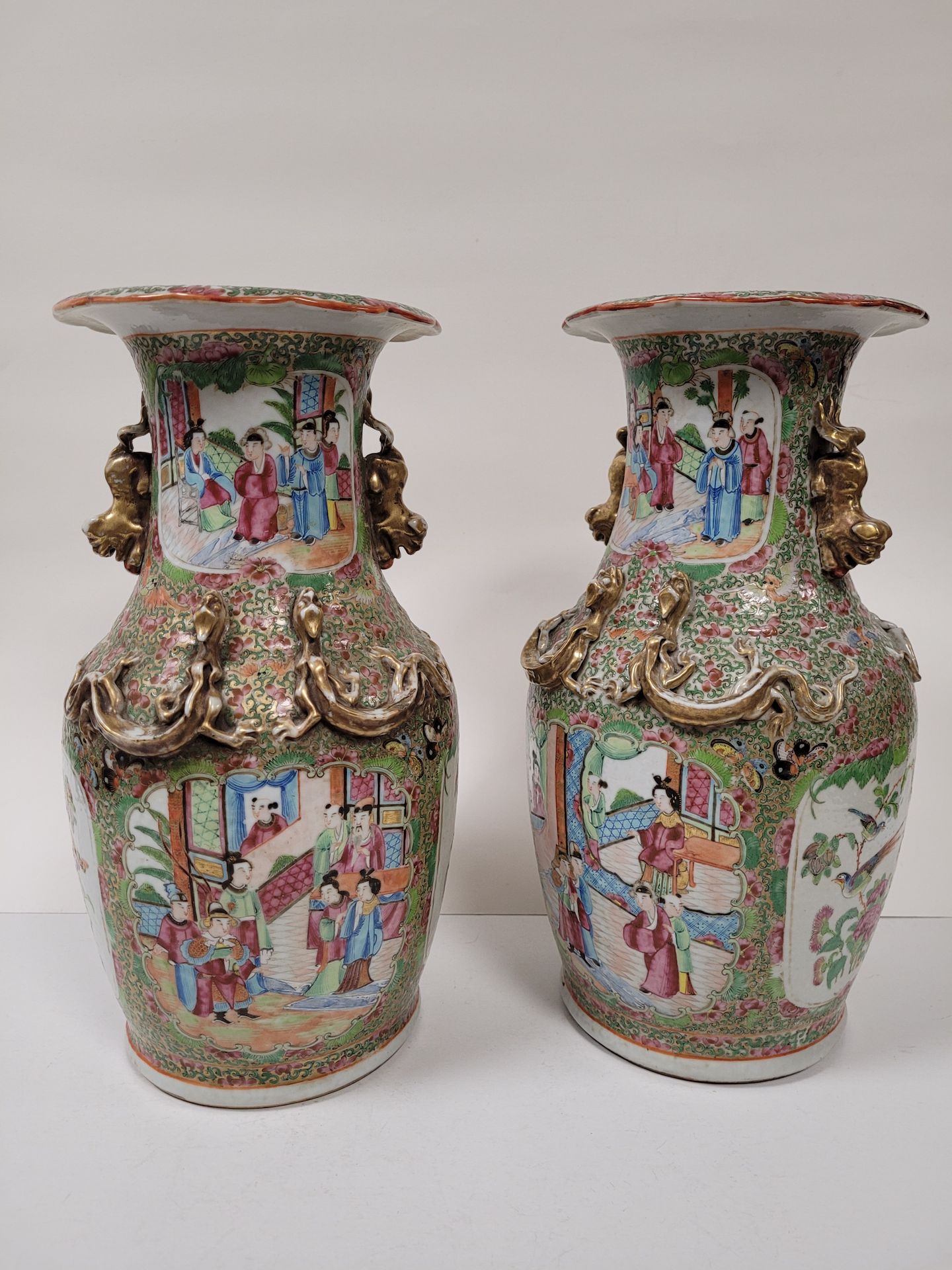 Null 一对瓷质柱形花瓶，广州，19世纪 一对瓷质柱形花瓶，
在卷轴背景上有人物和鸟类的预留装饰，奇美拉手，肩部有四个浮雕麒
麟。

高度：36厘米安装
在灯&hellip;