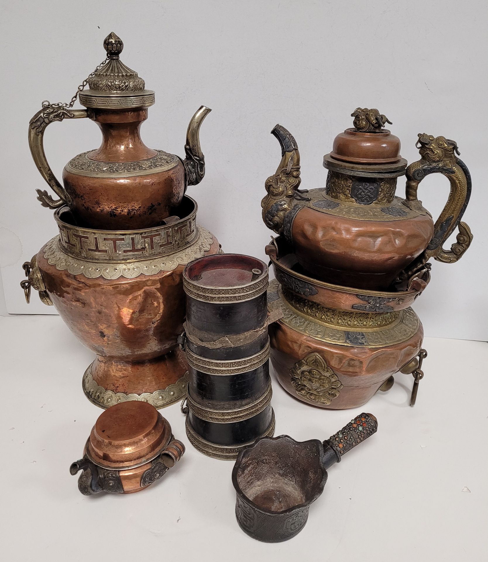 Null 
一套3个铜茶壶，西藏



由2个龙形手柄的大茶壶和它们的支架以及1个小茶壶组成。



其中包括一个小型便携式搅拌器和一个铁器，手柄上有石头装饰。&hellip;