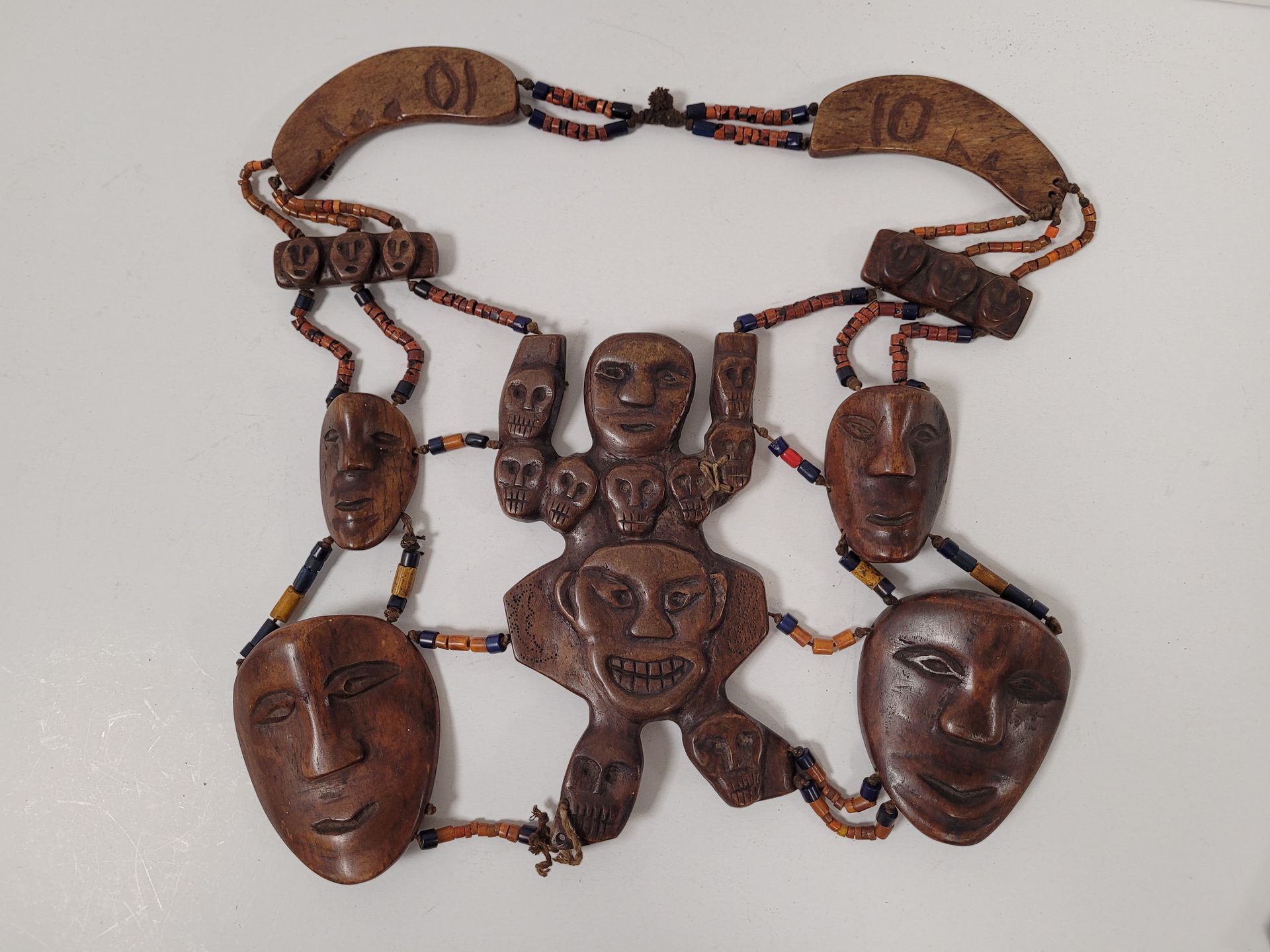 Null 一套4件装饰品，西藏或尼泊尔，20世纪其中
:
- 2个由小贝壳制成的装饰品，上面有一个铜制的无限结，最后是铃铛--
2条由木头雕刻的脸、骨珠和仿珊瑚&hellip;
