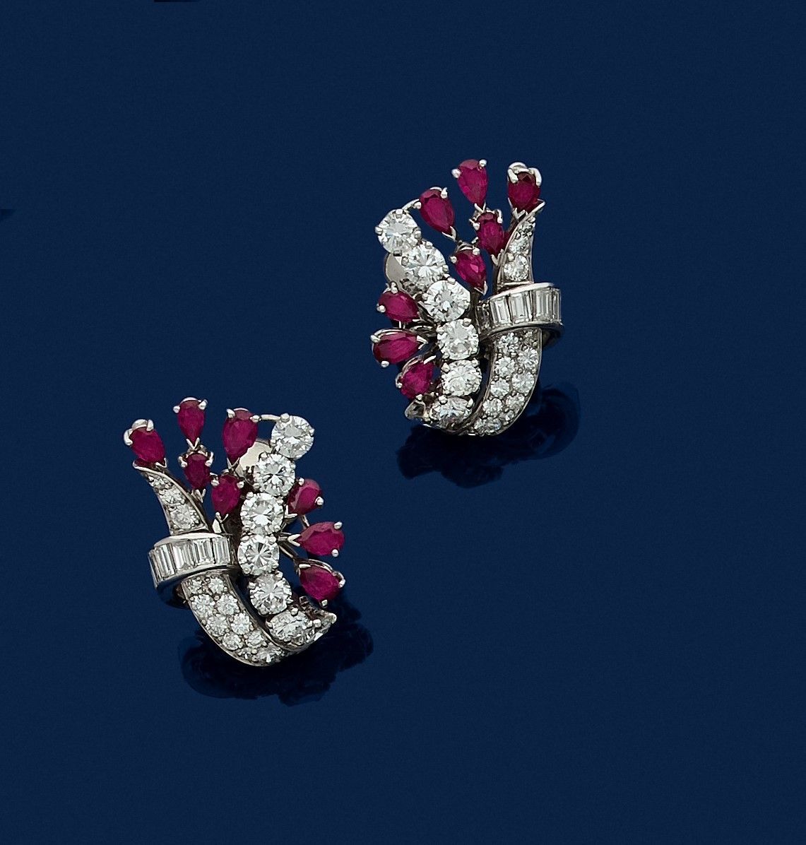 Null 一对铂金耳环，形成花形，镶嵌校准和圆形明亮式切割钻石，每个都点缀着水滴形切割红宝石。1970年代的工作。高度：约2.5厘米。毛重：18.1克

197&hellip;