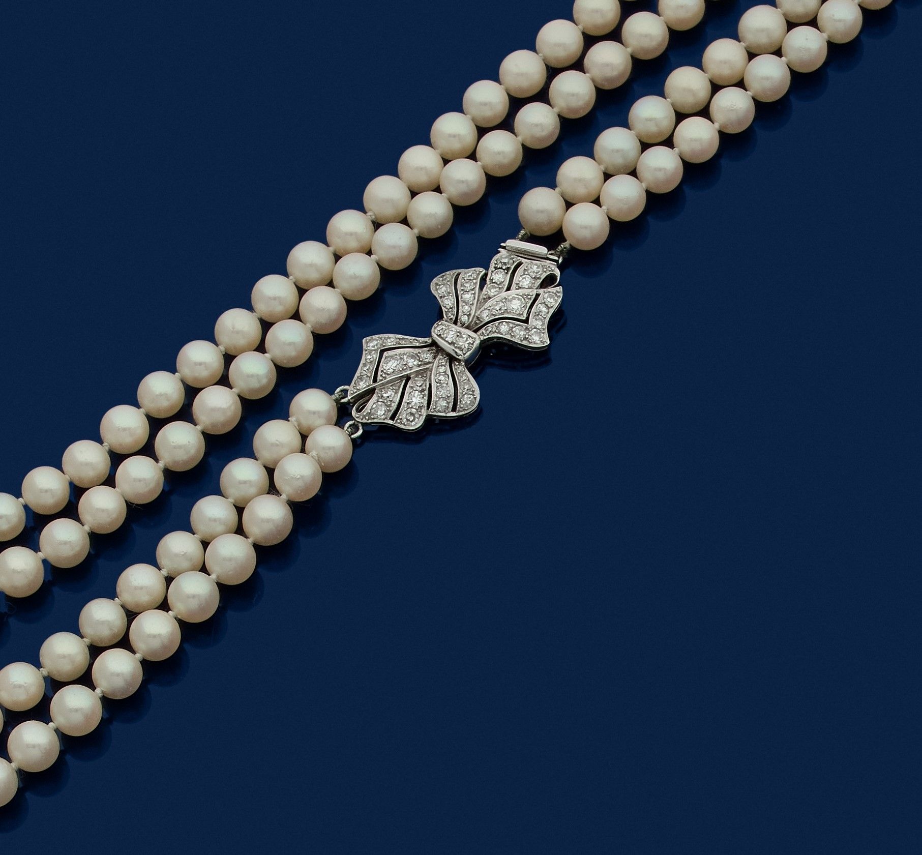 Null 两排养殖珍珠的项链，铂金蝴蝶结扣，镶嵌8/8圆钻。1950年代的法国作品。珍珠的直径：6.8毫米左右。扣子尺寸：3.6 x 1.9毫米左右。长度：50&hellip;