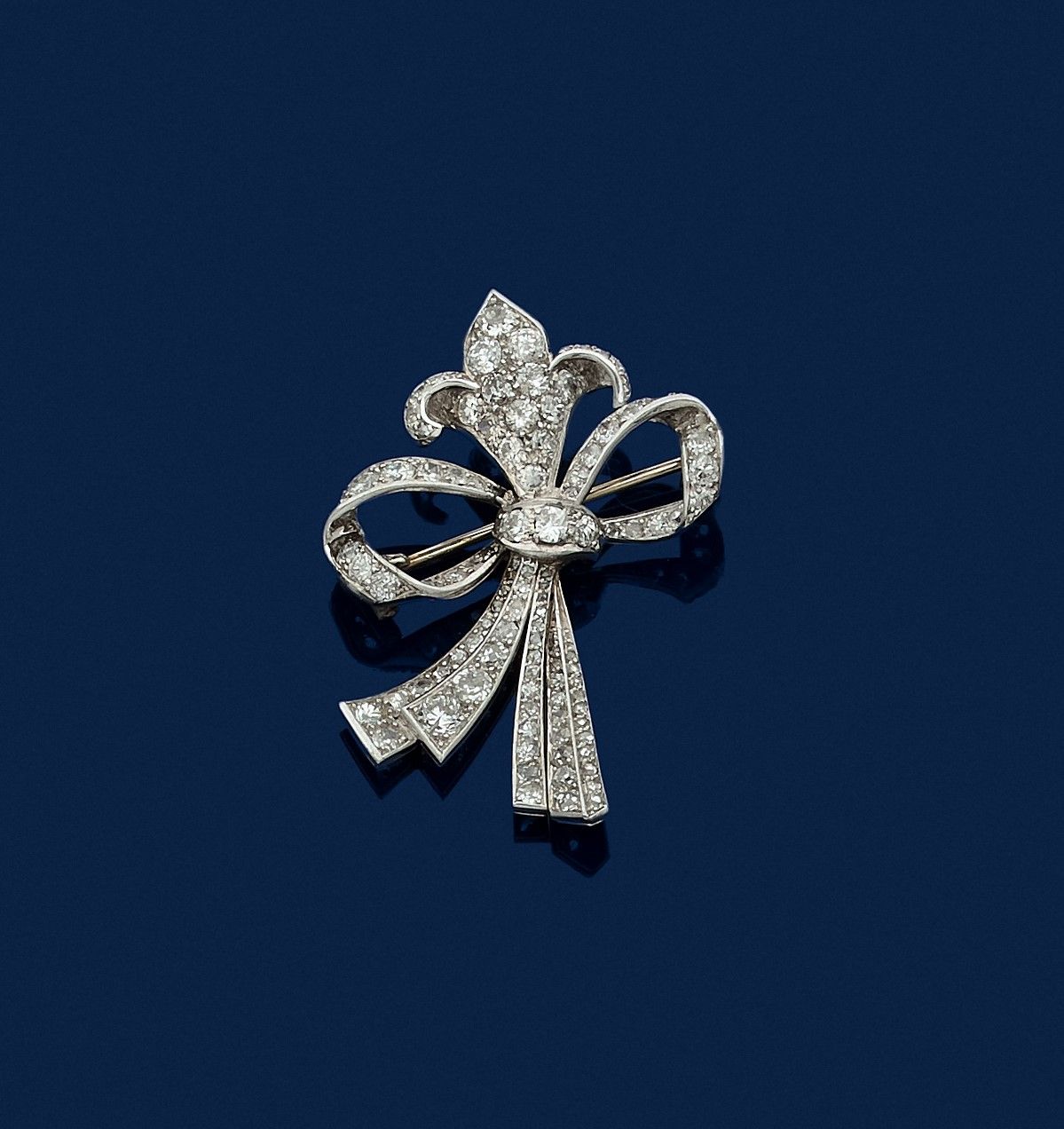 Null 一枚铂金胸针，在一个丝带结中画着一朵百合花，上面镶嵌着8/8和老式切割钻石。高度：约4.2厘米。毛重 : 9,7 g

镶嵌钻石的胸针