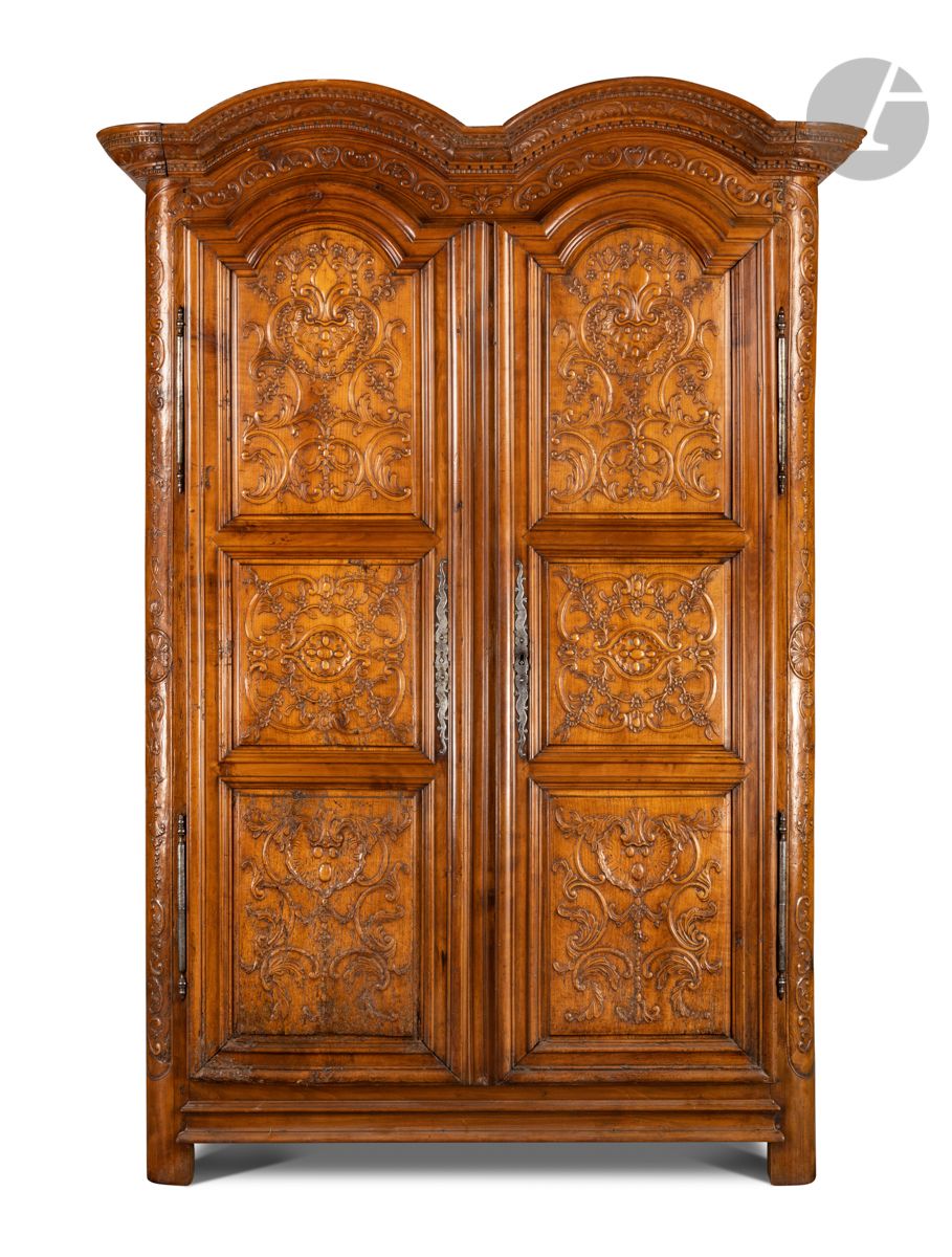 Null 一个模制和雕刻的果木橱柜，有两扇门，装饰有叶子、棕榈、贝壳、花和扣子，檐口靠在圆形的立柱上；（事故和修复）。
18世纪。
高：220厘米，宽：137厘&hellip;